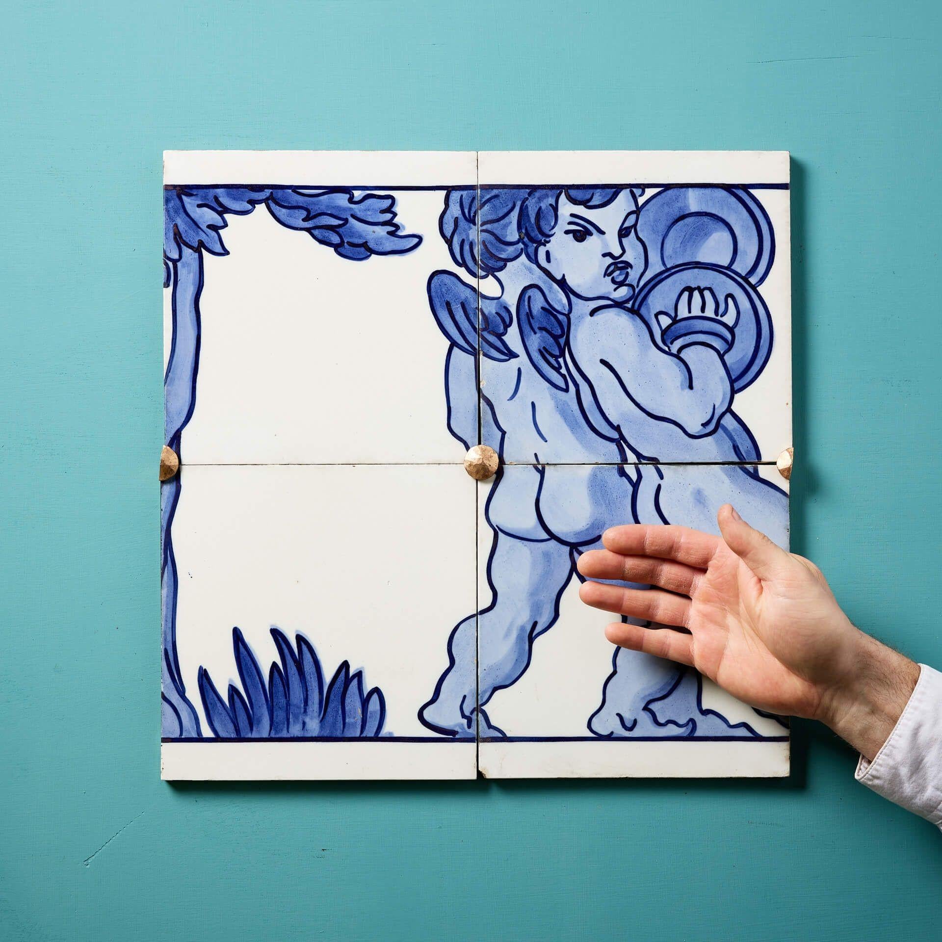 A set of 4 antique dust-pressed ceramic tiles by Minton Hollins (stamped) creating a decorative blue and white glazed frieze panel depicting a pair of neoclassical style winged cherubs playing cymbals.

Once part of a larger design, this is just one