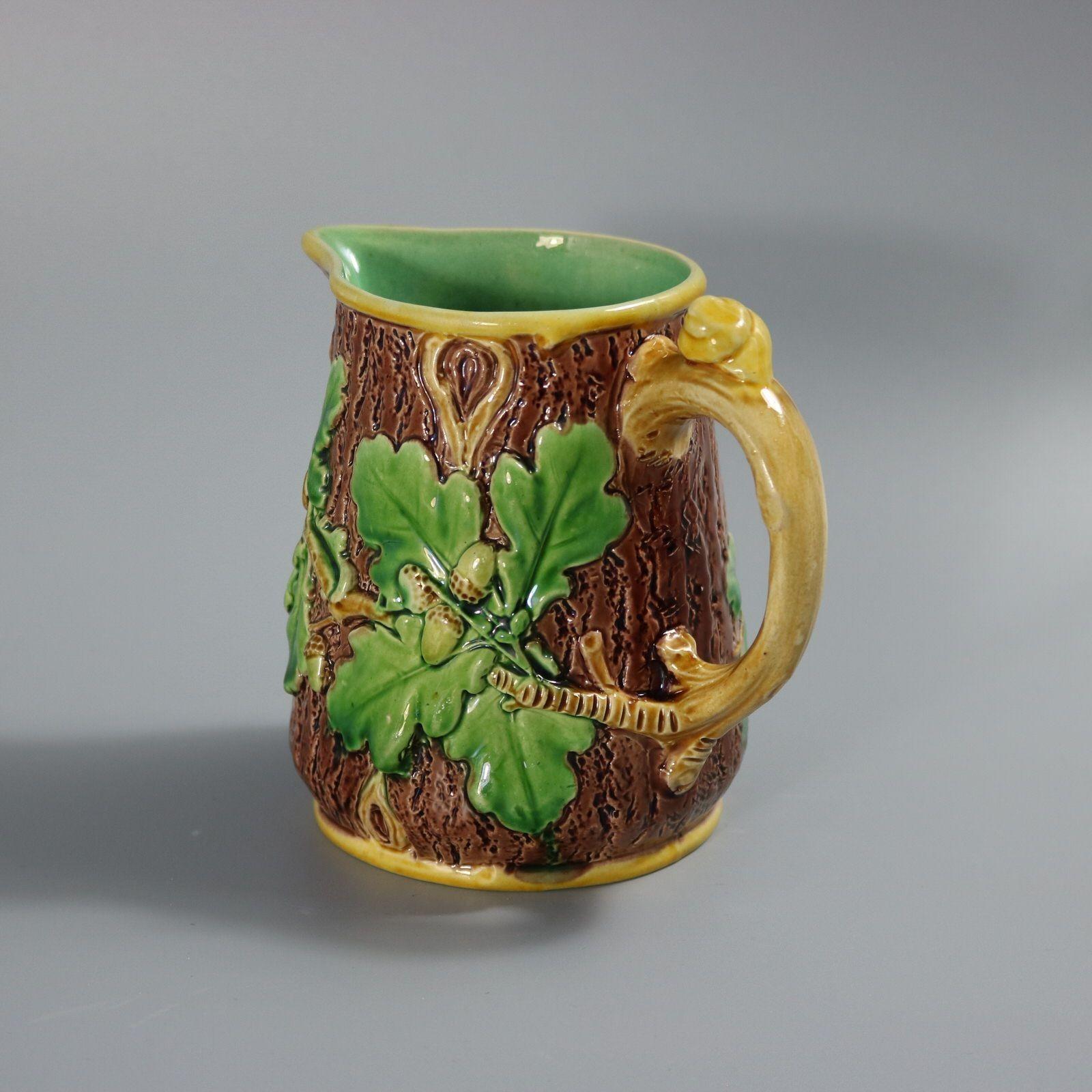 Brocca/pentola in maiolica di Minton con foglie e ghiande di Oak sui lati e una lumaca sul manico. Colorazione: predominano il marrone, il verde e l'ocra. Il pezzo reca i marchi di fabbrica della ceramica Minton. Porta un numero di modello, 