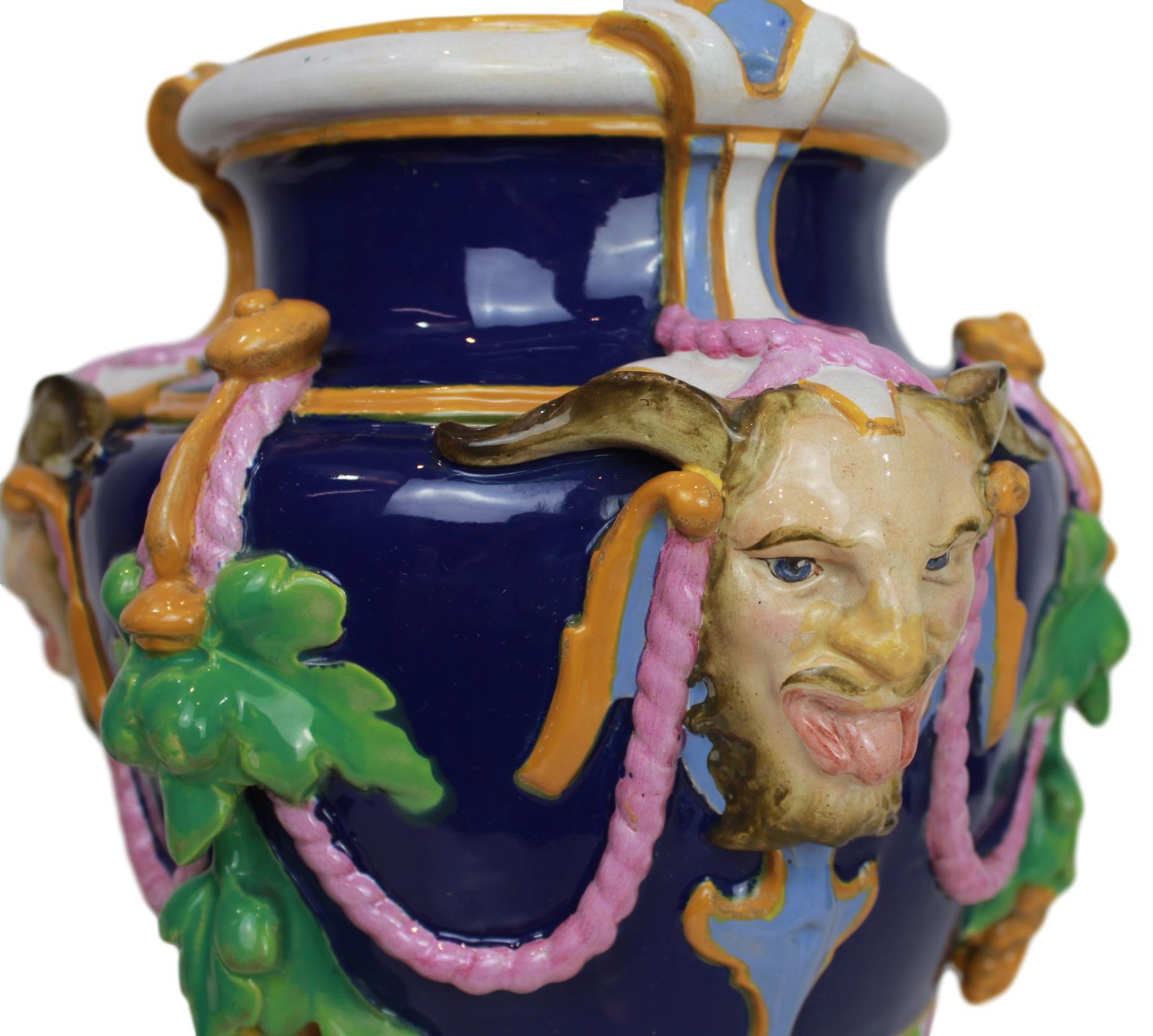 Minton Majolica 'Bacchus' vase cobalt blue-ground, English, dated 1856, of urn-shaped form, molded and applied with three satyr masks, and festoons of pendant fruit, suspending rope-twist swags above gadrooned lower section, on pedestal stem and