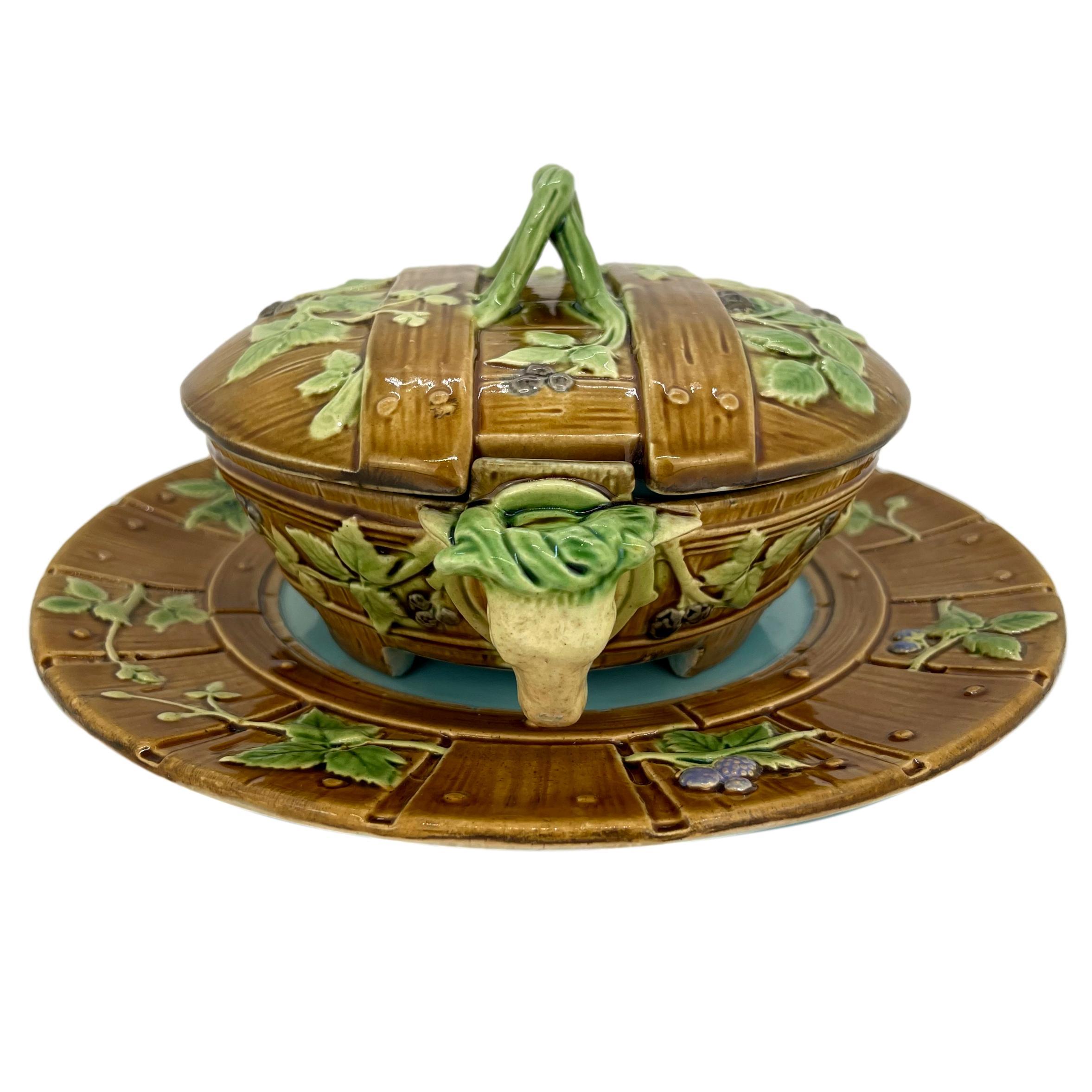 Minton Majolica butter dish, Lid, and Underplate, molded as wooden staves with blackberries and vines with cow's heads wearing green glazed garlands as handles, the reverse of the dish with impressed marks: 'MINTON,' and Minton date cypher for 1867,