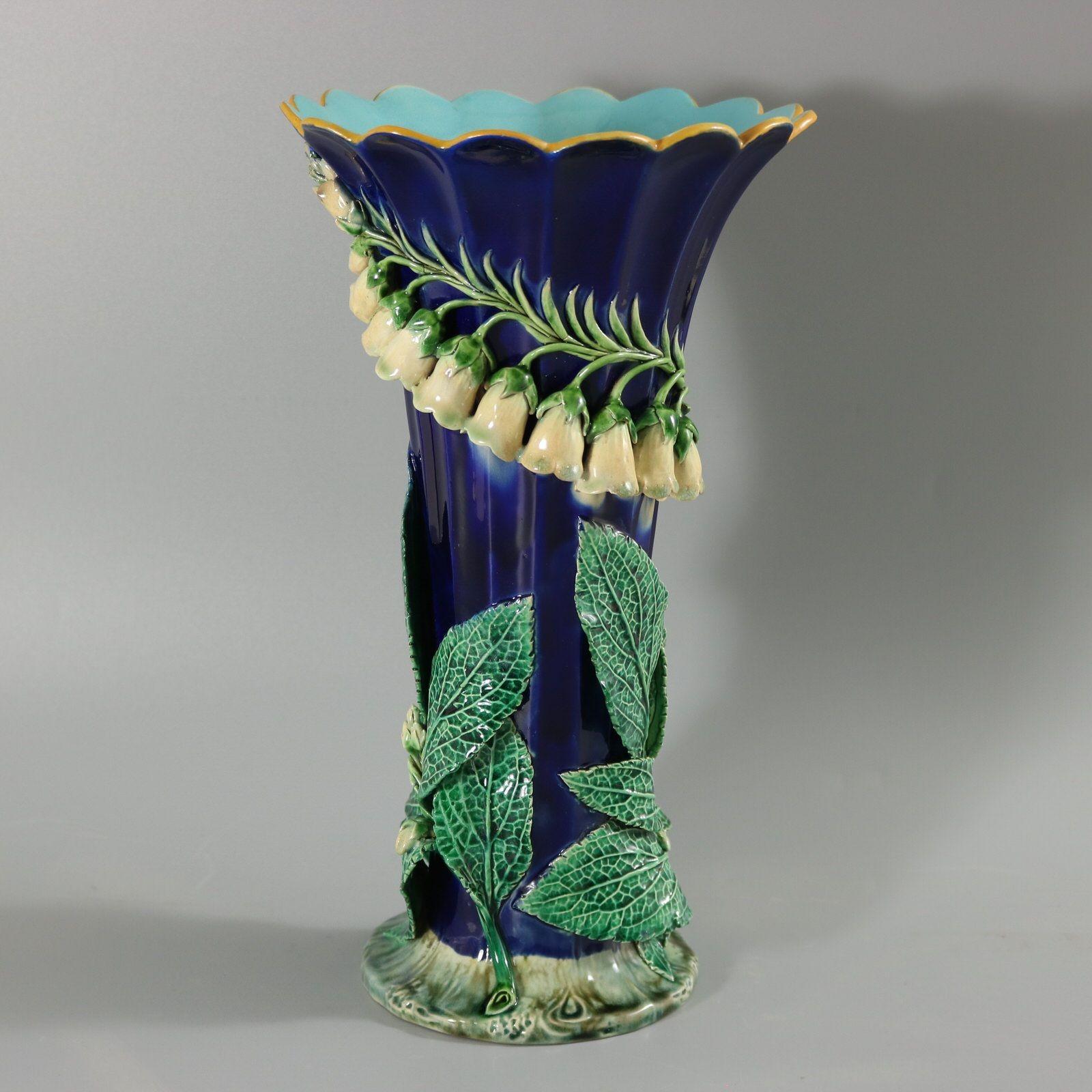 Minton Majolica vase which features foxglove flowers and leaves in deep relief. Colouration: cobalt blue, green, white, are predominant. The piece bears maker's marks for the Minton pottery. Bears a pattern number, '1757'. Marks include a factory