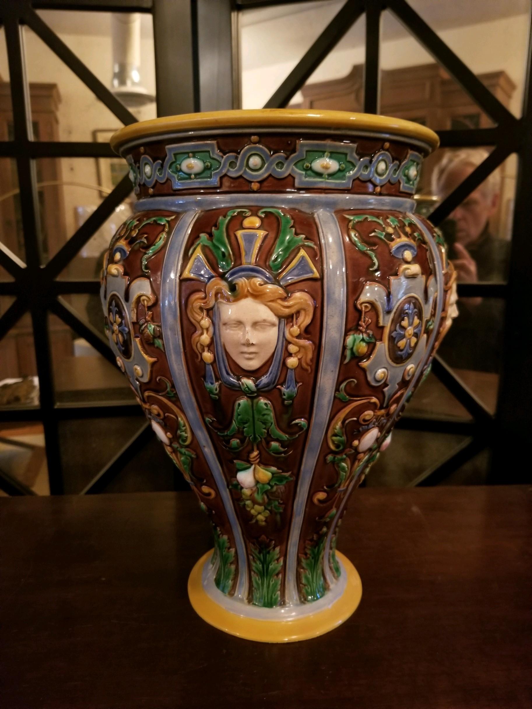 
Minton Majolica jardinière (large vase) of Roman inspiration. Beautifully detailed and colored. Small stress crack at top probably a kiln issue, does not affect value or stability. It is washed in the Classic blue interior. 14” tall by 9” wide