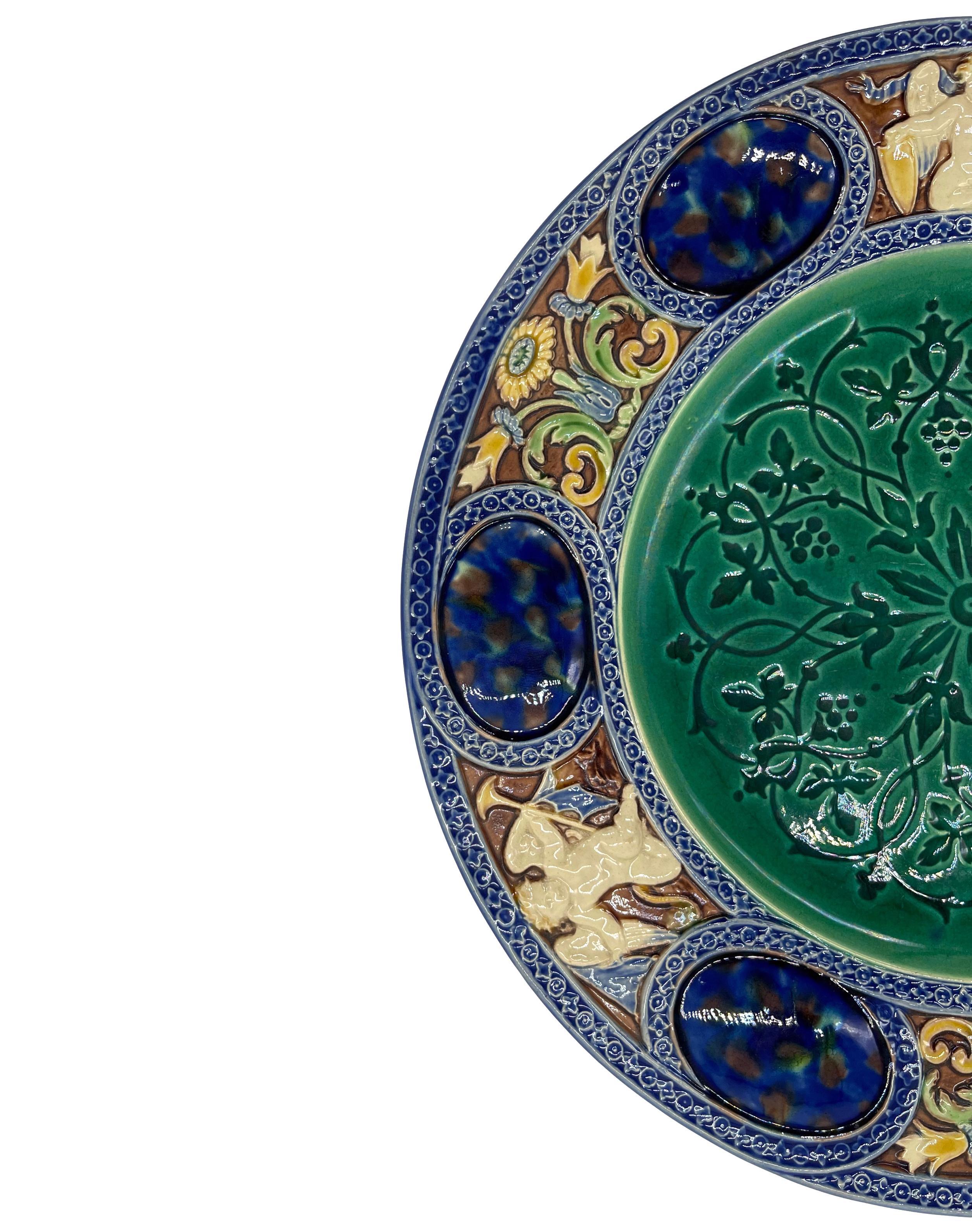 Assiette de cabinet en majolique de Minton, avec un motif central médiéval en émail-ombrant, une technique difficile obtenue en inondant les glaçures de majolique sur un motif en creux, faisant apparaître les cavités imprimées comme des ombres de