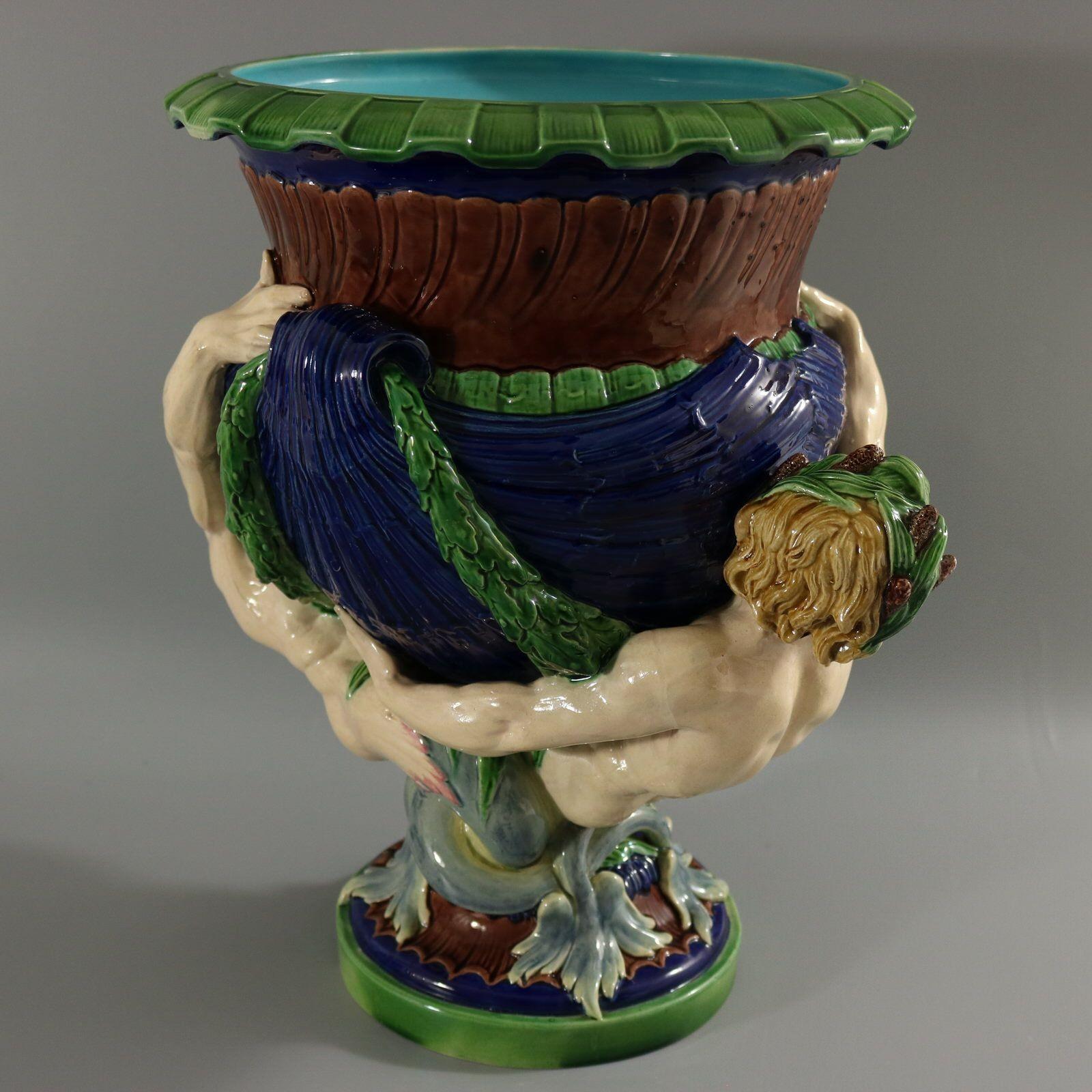 Minton Majolika-Jardiniere mit einem mythologischen Thema, das zwei Wassermänner (manchmal dem Meeresgott Neptun oder Triton zugeschrieben) zeigt, die Muscheln tragen. Version mit kobaltblauem Boden und türkisfarbener Innenausstattung. Färbung: