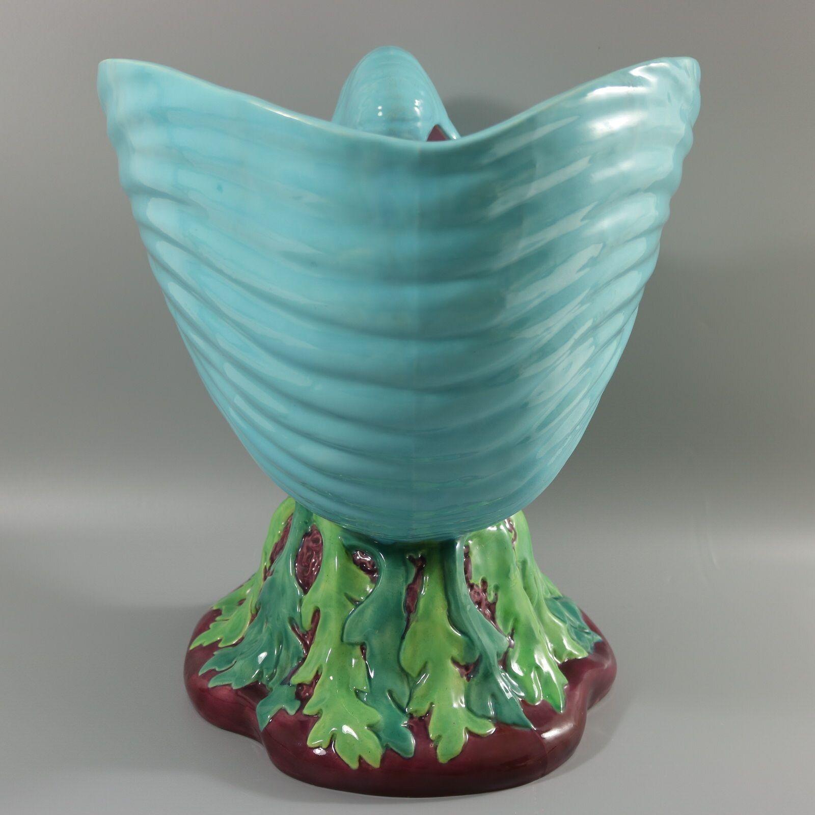 Minton Majolica flower pot (jardiniere) which features a nautilus shell on a coral-like base which is draped in seaweed. Colouration: turquoise, green, magenta, are predominant. The piece bears maker's marks for the Minton pottery. Bears a pattern