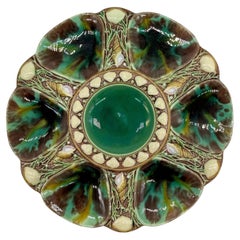 Assiette à huîtres en majolique de Minton, vert moucheté, marron, jaune, anglaise, datée de 1875