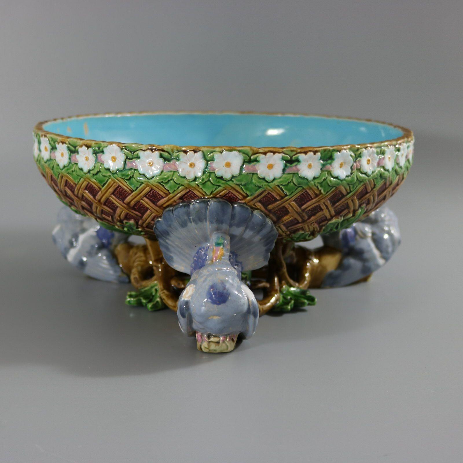 Coupe de centre de table en majolique de Minton représentant trois pigeons perchés sur une branche de chêne feuillue, soutenant un grand bol en vannerie sur leurs queues en éventail. Le bol est décoré de feuilles de chêne et d'une bande de fleurs de