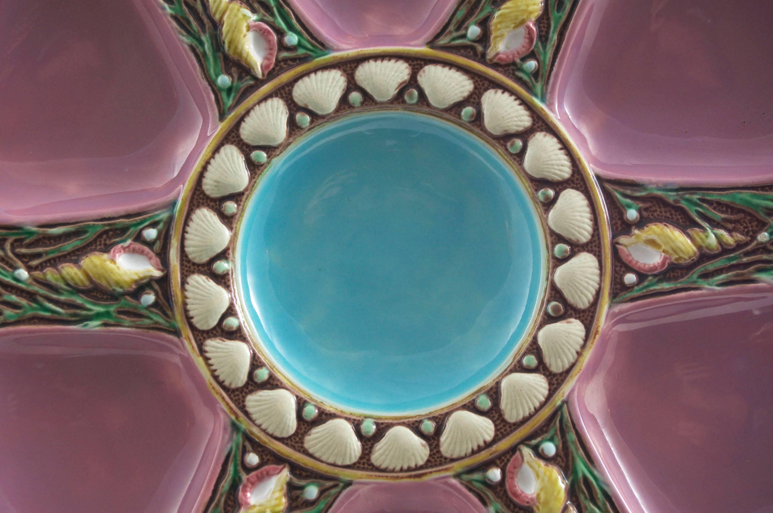 Minton Majolica oyster plate in pink; Six spokes and central well; Shell and seaweed ornamentation on each spoke; Impressed Minton; four available shape number 1323 with Minton date marks for 1873, 1874, and 1875.
For over 28 years we have been