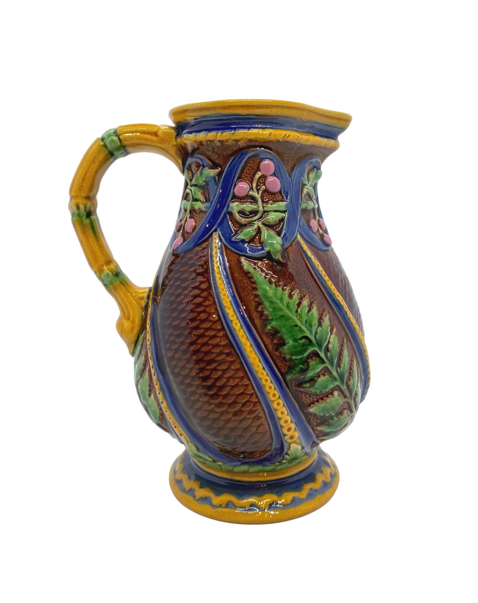 Minton Majolica pitcher with ferns and pink berries, the reverse with impressed British Registry lozenge and Minton date cipher for 1860.
This design is included in the Karmason Library of the Majolica International Society with the designation: