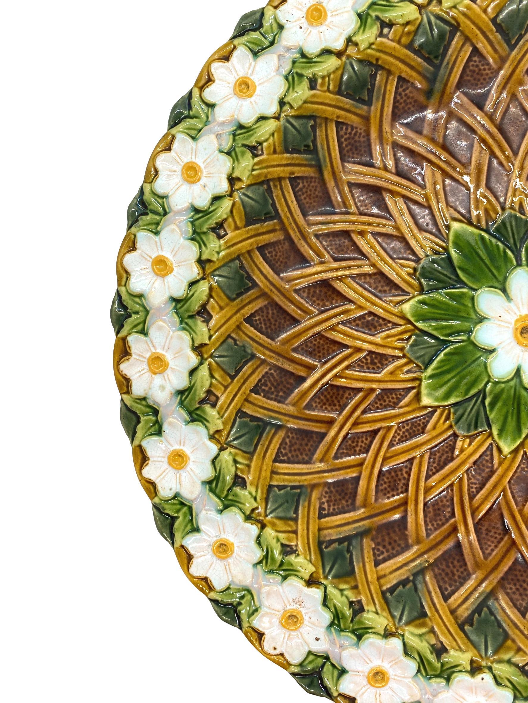 Minton Majolica platter, molded in high relief with a central medallion of leaves and a daisy, surrounded by basketweave latticework, with a continuous chain of daisies forming the border, impressed marks to reverse, 'MINTONS' and Minton date cypher