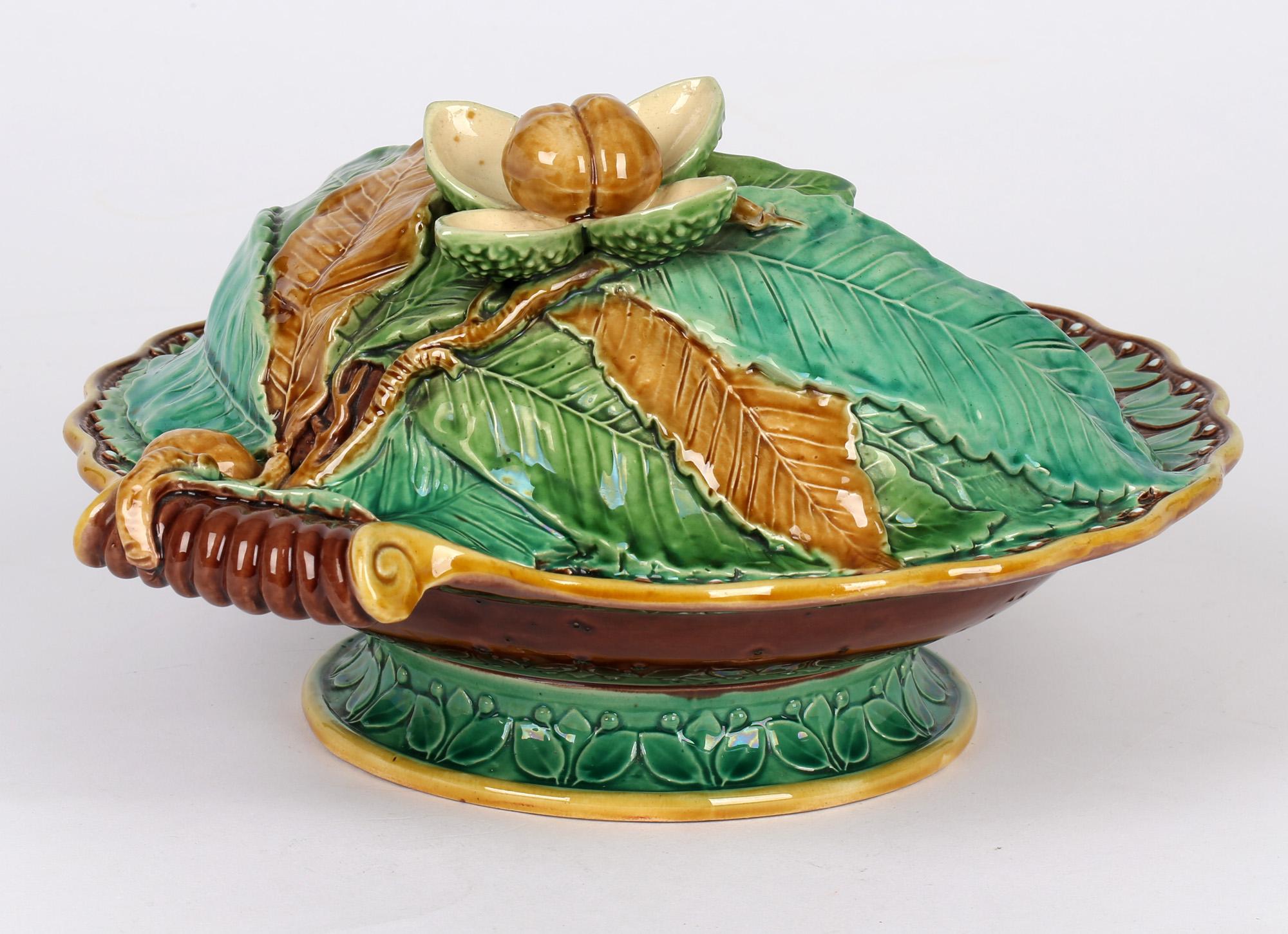 A very fine antique Minton majolica pottery handled pedestal chestnut dish dated 1867. The dish stands on a rounded pedestal foot the edge molded in relief with petal designs supporting a rounded bowl with a curled handle to one side and with