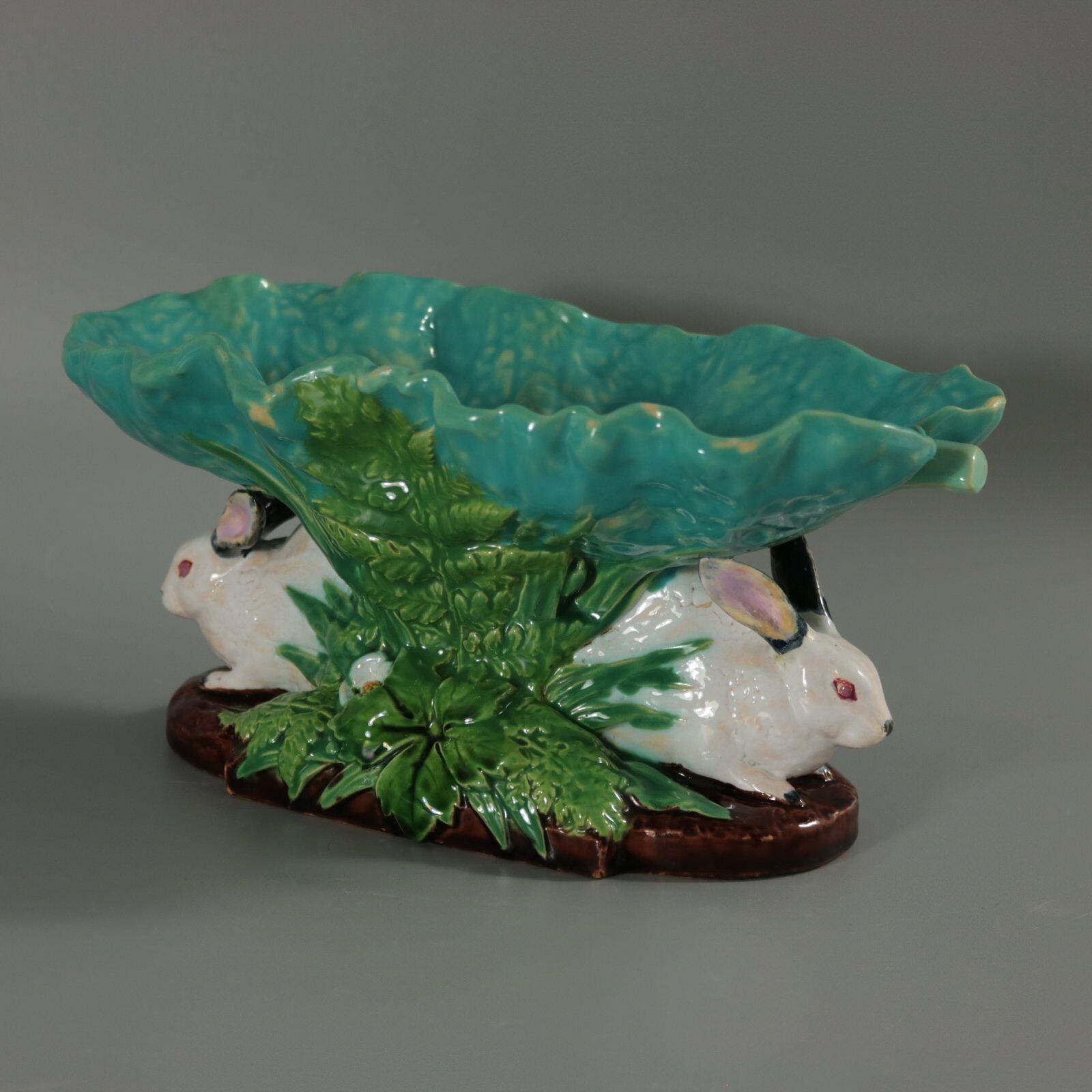 Minton Majolica figural bowl which features two rabbits amongst foliage, supporting a leaf. Colouration: turquoise, green, white, are predominant. The piece bears maker's marks for the Minton pottery. Bears a pattern number, '1451'. Marks include a