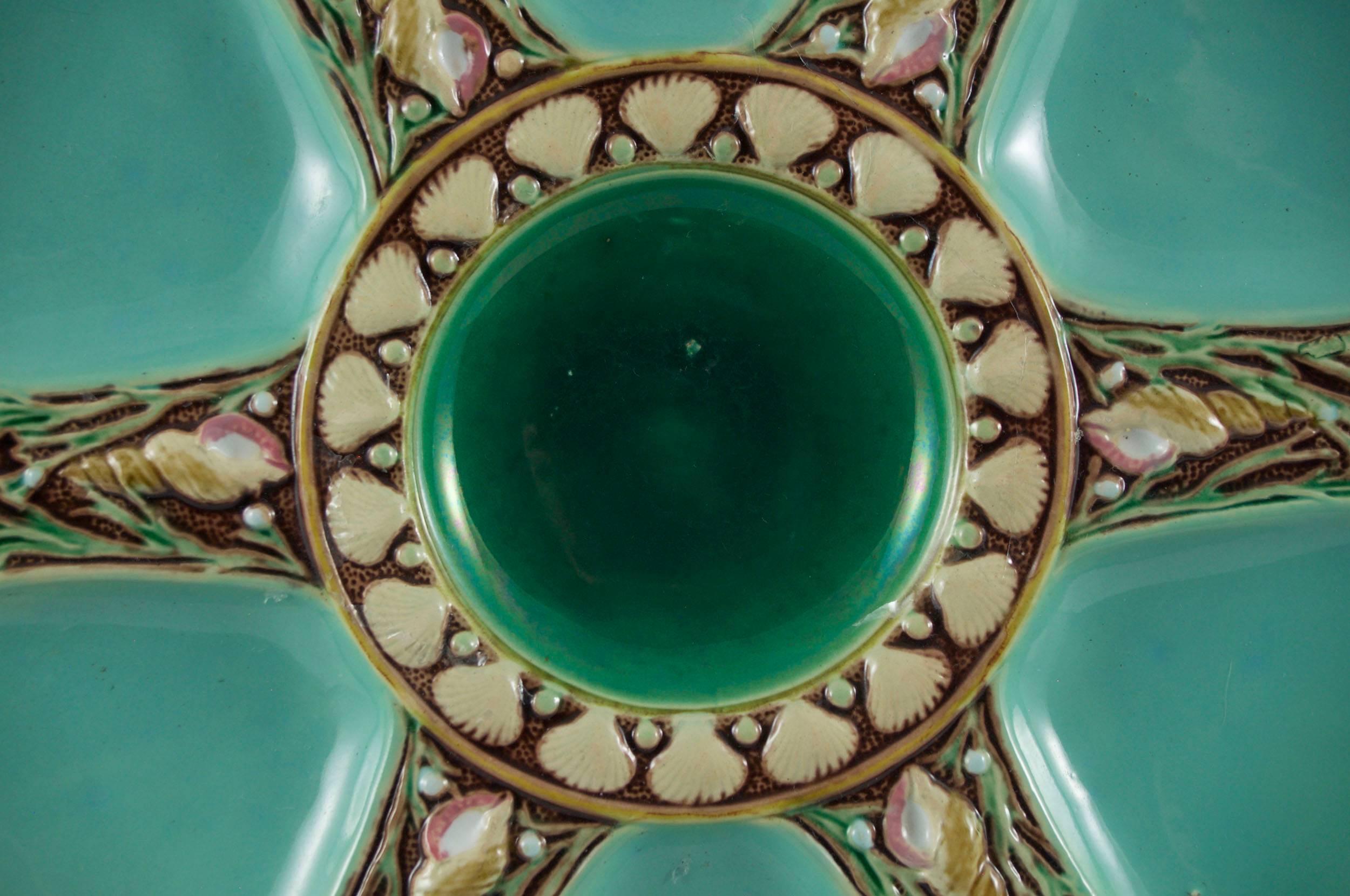 Minton oyster plate in turquoise; six spokes and central well; shell and seaweed ornamentation on each spoke; impressed MINTON; Shape number 1323 with Minton datemark for 1873.

Literature:
Marilyn G. Karmason and Joan B. Stake, Majolica: A