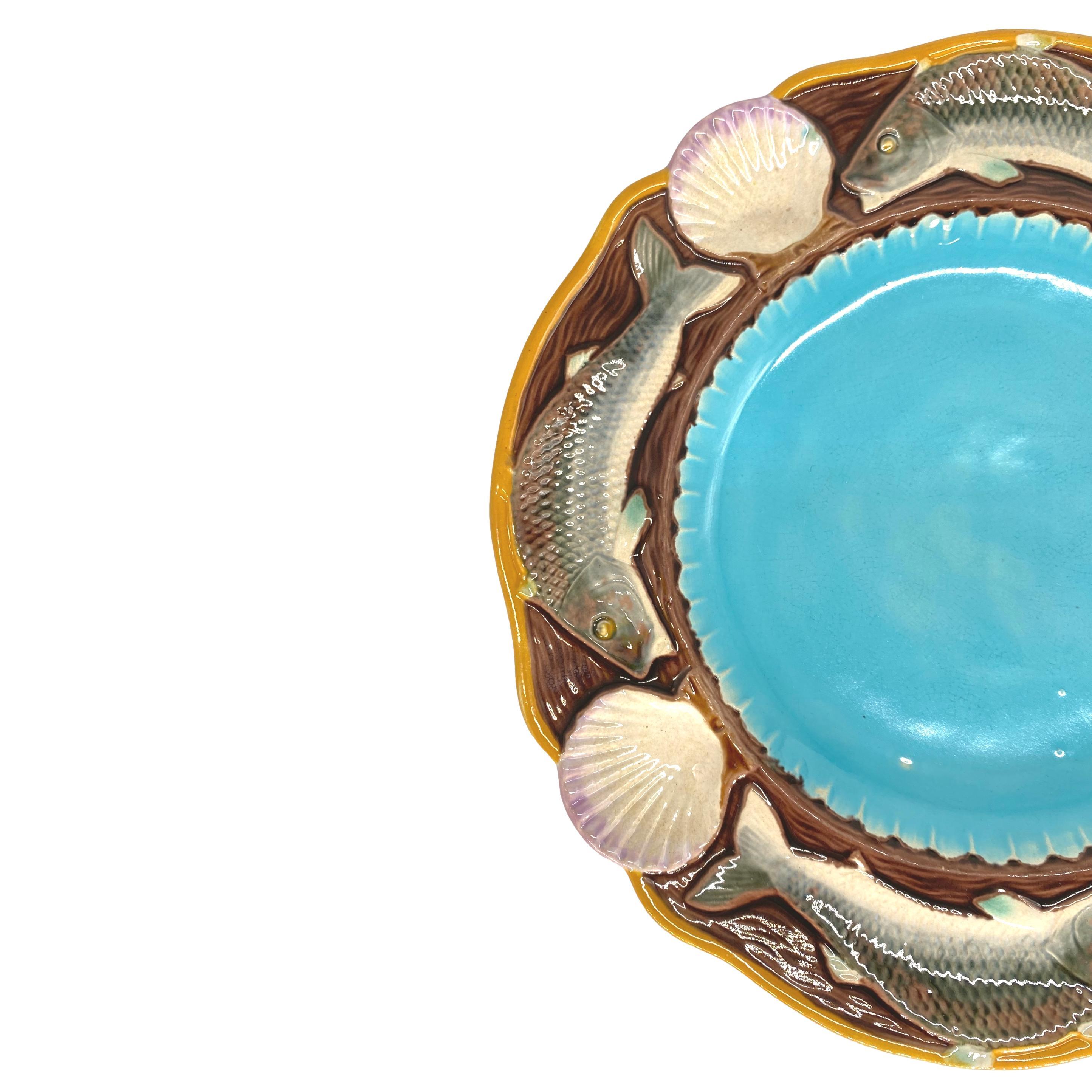 Assiette à fruits de mer en majolique de Minton avec poissons et coquillages, anglaise, datée de 1873, le centre festonné émaillé en turquoise, bordé de poissons et de coquilles Saint-Jacques émaillés de façon naturaliste et moulés en relief,