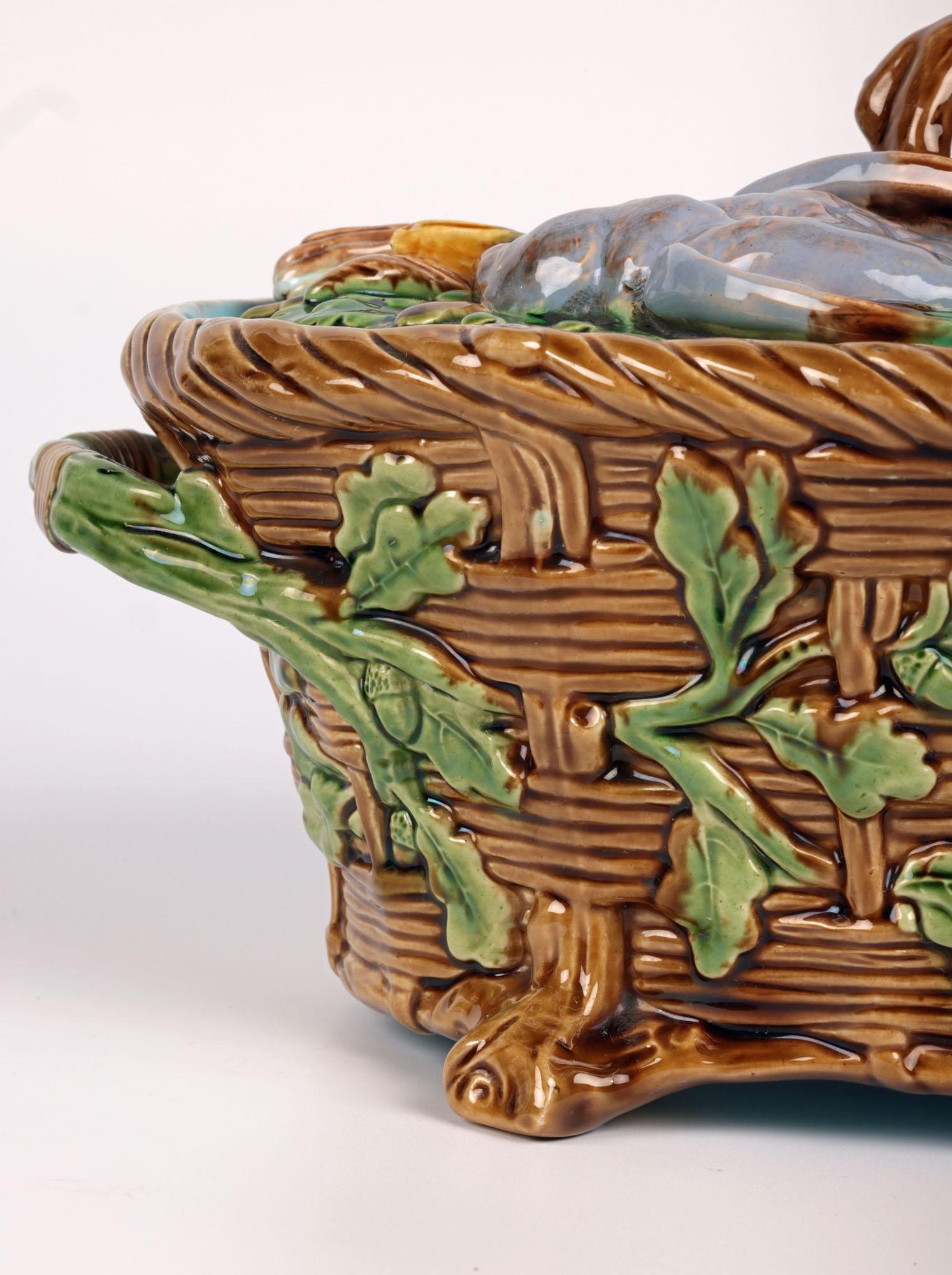 Elegante e impresionante plato y tapa antiguos de cerámica mayólica inglesa para tartas de caza, del conocido y codiciado fabricante Minton y fechados en 1867. El plato de barro se alza sobre cuatro pequeñas patas esquineras de ramita y tiene forma