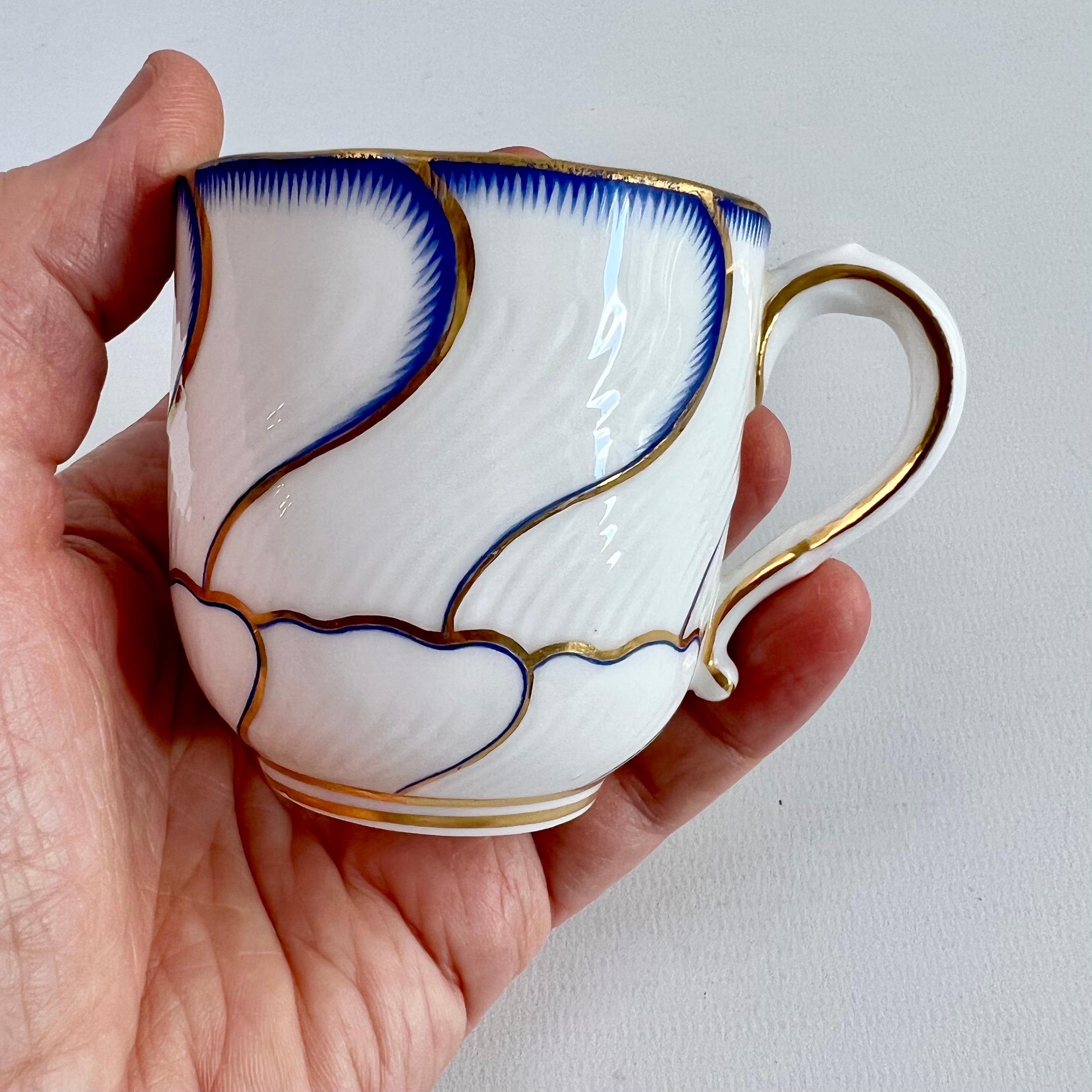 This is a sublime little orphaned coffee cup made by Minton around the year 1881. It would make a perfect gift for the holidays.

The cup is spirally fluted and has a very striking pattern of flowing sections, each bordered by a blue 