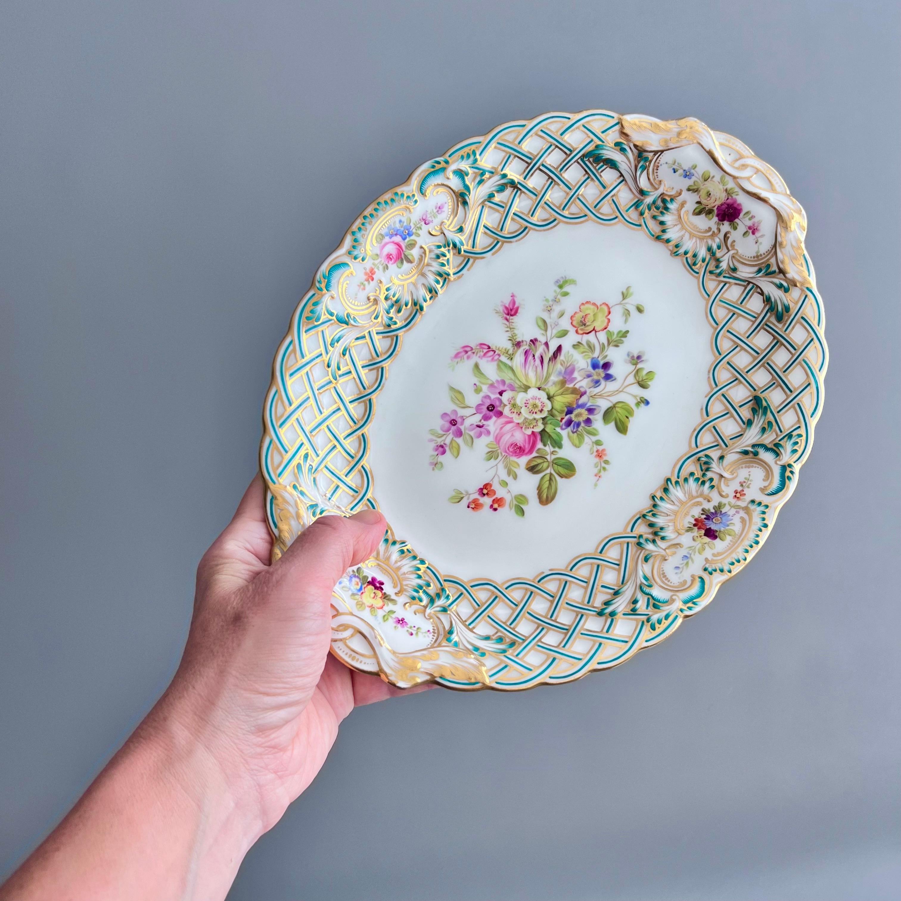 Se trata de una impresionante pareja de platos ovalados fabricados por Minton en 1857. Los platos están bellamente moldeados con la forma repujada de Newcastle, la moldura recogida y turquesa y dorada, y pintados a mano con flores por Joseph