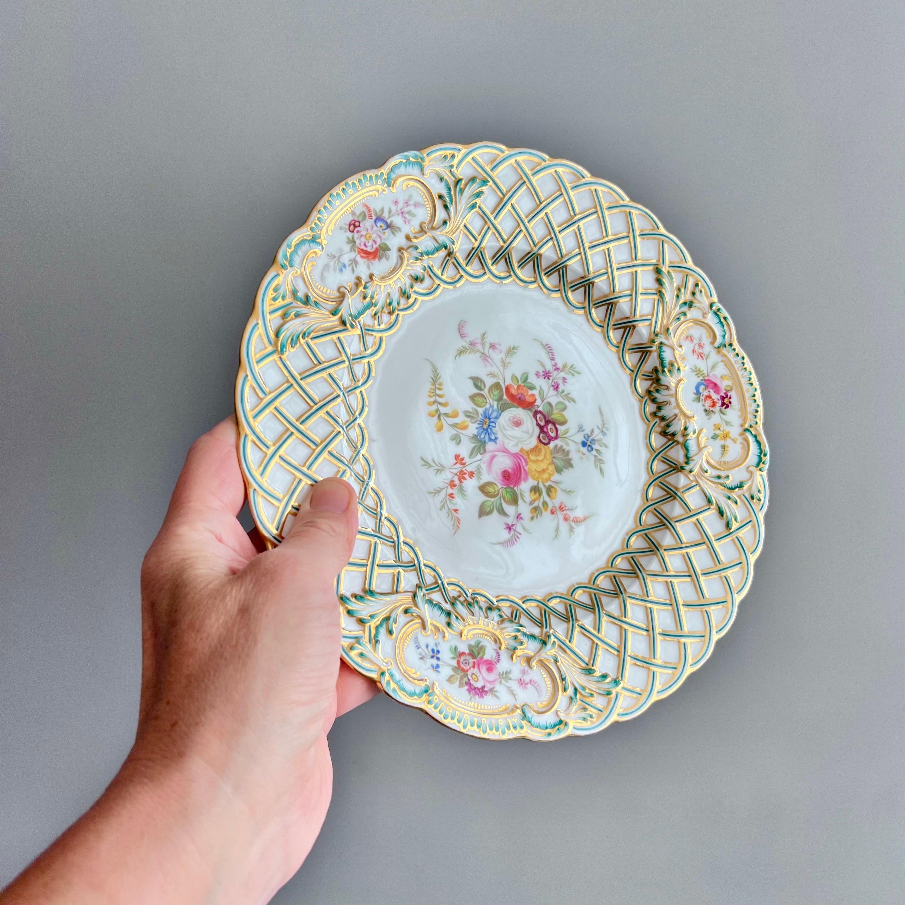 Se trata de una impresionante pareja de platos fabricados por Minton en 1857. Los platos están bellamente moldeados con la forma repujada de Newcastle, la moldura recogida y turquesa y dorada, y pintados a mano con flores por Joseph Bancroft. Estos