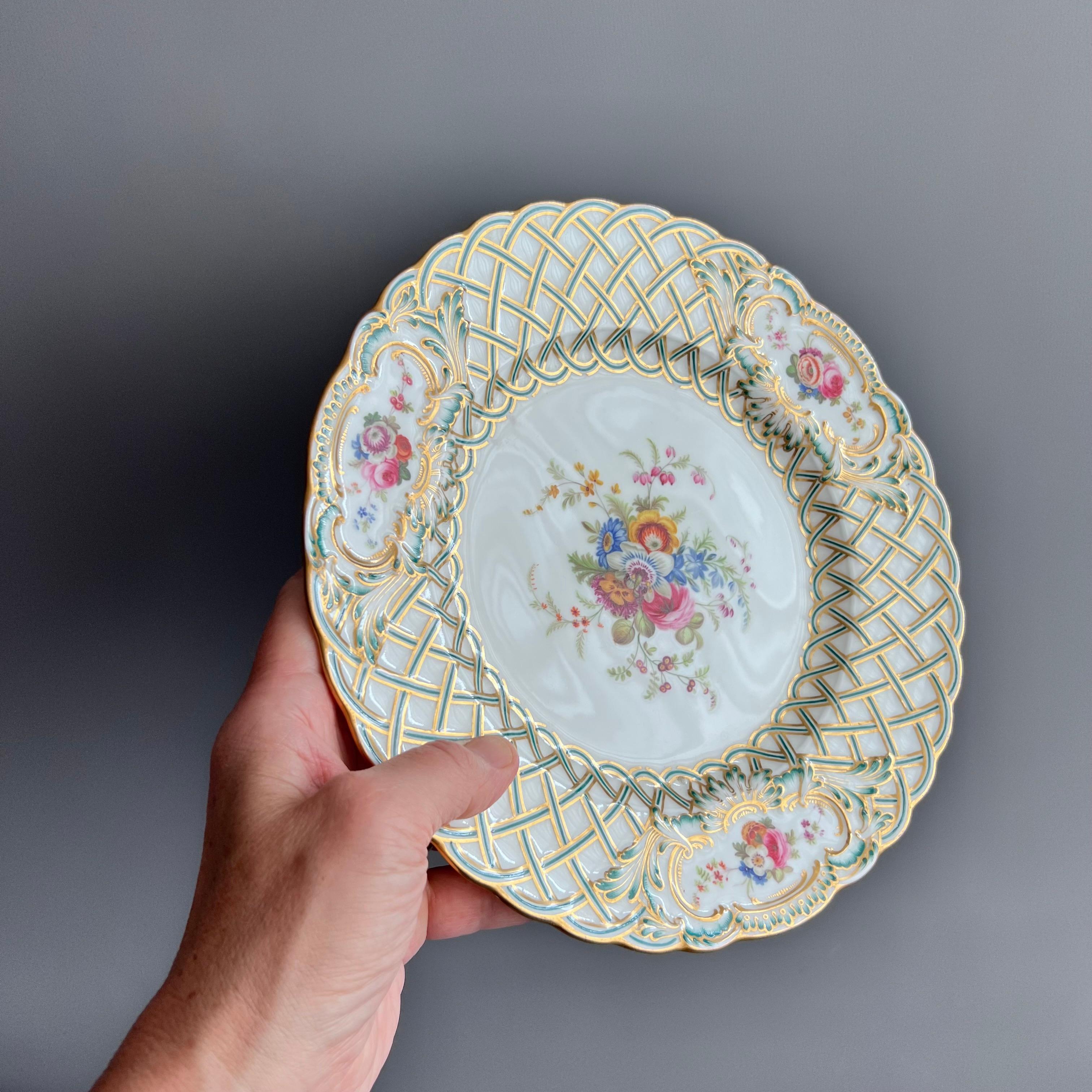 Dies ist ein wunderschöner Teller von Minton aus dem Jahr 1857. Der Teller ist wunderschön in der Newcastle Embossed Form geformt, die Leisten sind türkisfarben und vergoldet und von Joseph Bancroft mit Blumen handbemalt. Dieser Teller gehörte zu