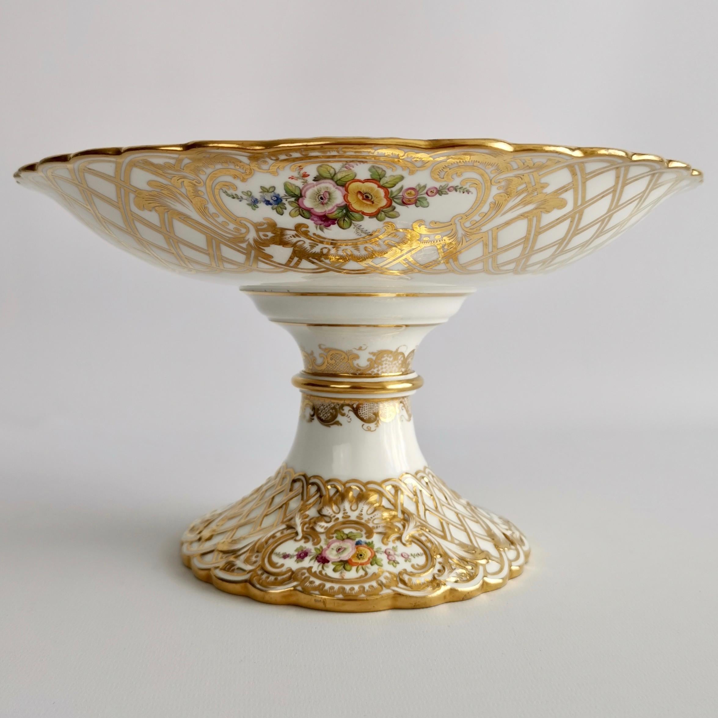 This is a stunning and rare part-dessert service made by Minton in 1841, which was the Rococo Revival era. It is beautifully moulded in the Newcastle Embossed shape and hand painted with flowers by Joseph Bancroft. The set consists of two high
