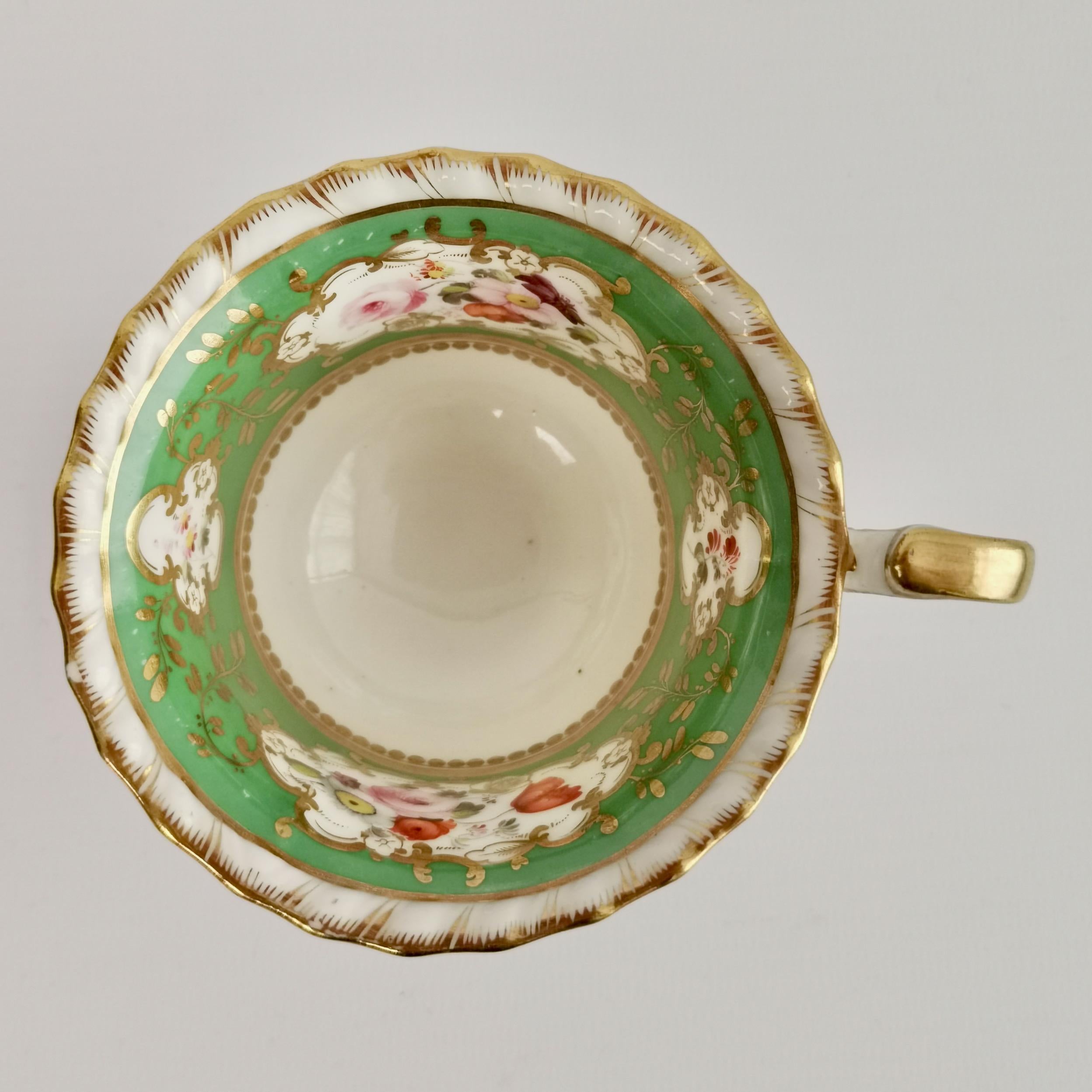 This is a charming orphaned coffee cup made by Minton around the year 1825, which was the Regency era. The cup is decorated with a bright green band and finely painted flower reserves.
 
Minton was one of the pioneers of English china production