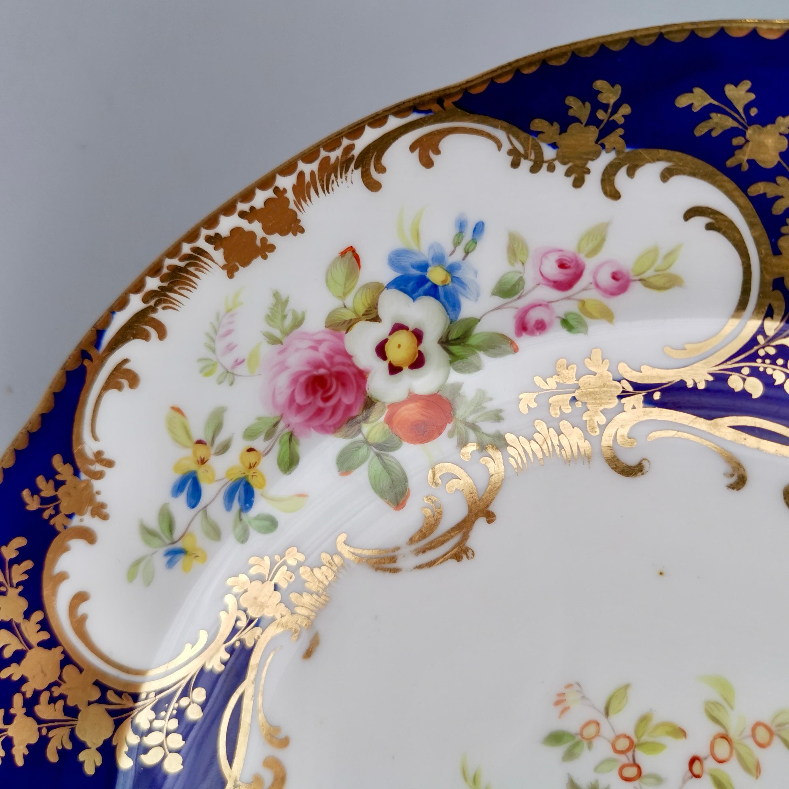 This is a beautiful dessert plate made by Minton in about 1840. The plate has a beautiful deep cobalt blue ground with three floral reserves surrounded by fine gilding, and a fourth flower arrangement in the centre. The flower painting and gilding