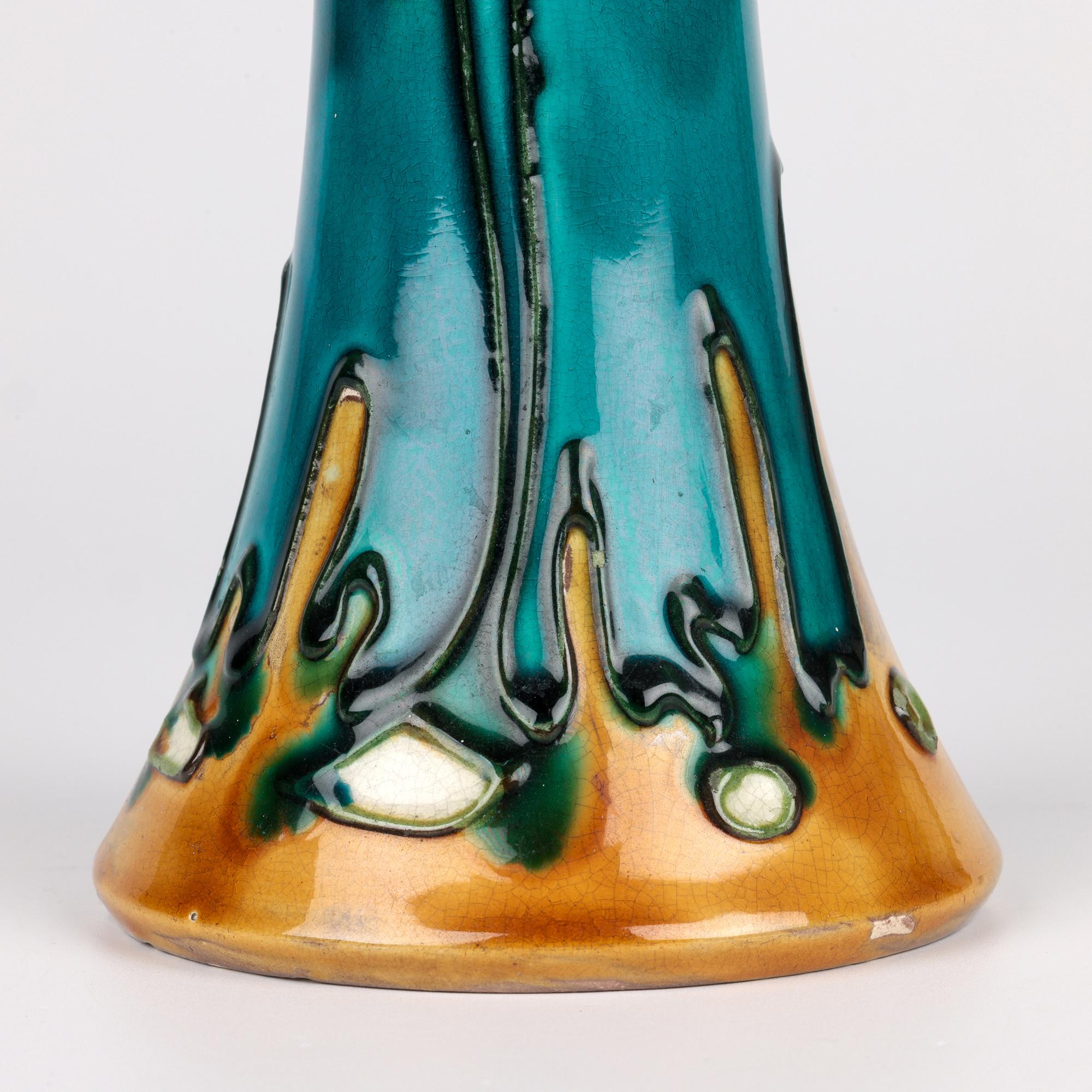 Un très élégant vase à deux anses en poterie d'art doublé d'un tube Art Nouveau de Minton, modèle No 41, datant d'environ 1900. Le vase en poterie repose sur un large pied à jupe non émaillé, avec une base émaillée crème légèrement en retrait. Le