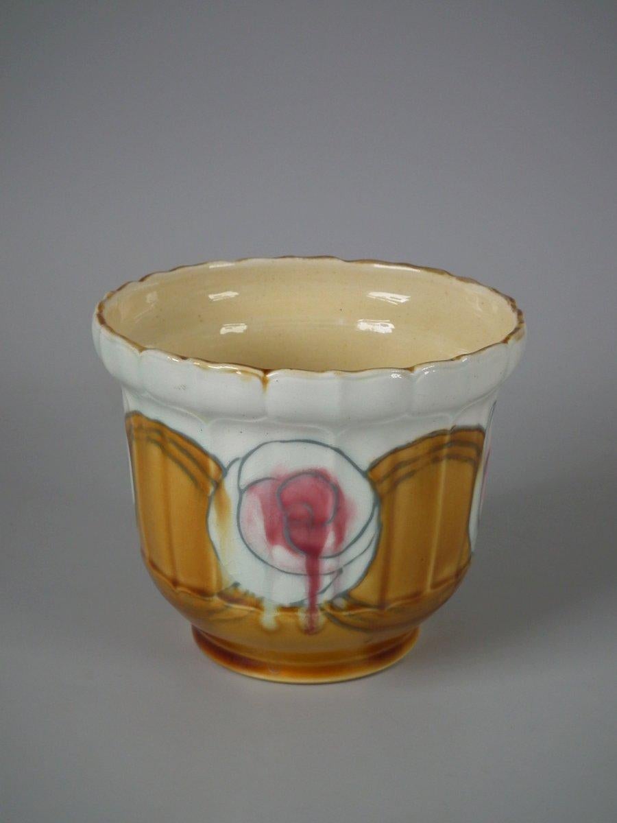 Minton Secessionist No. 48 planter. Decorated with stylized roses glazed in pink, orange and cream with grey tube lining. Maker's marks to underside include printed, 'MINTONS LTD. No.48' and impressed 'MINTONS ENGLAND 3190 7'.
 