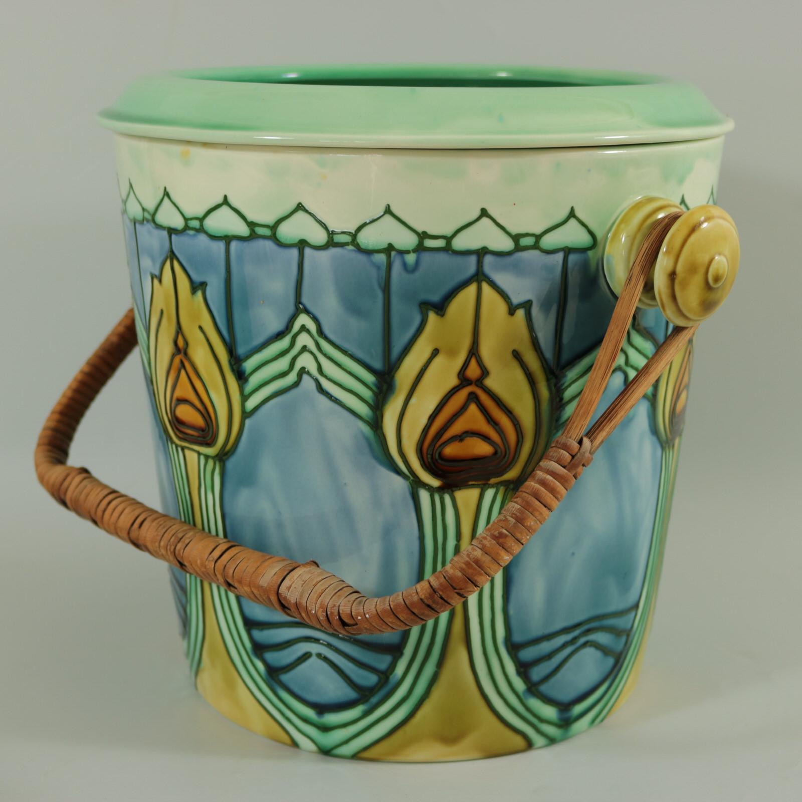 Minton Secessionist Bucket or Pail with a Drainer insert. Decorated with Art Nouveau style geometric and floral motifs. Blue, green and yellow glazes. Original bamboo handle. Removable drainer. Maker's marks including printed 'MINTONS LTD. NO. 36'