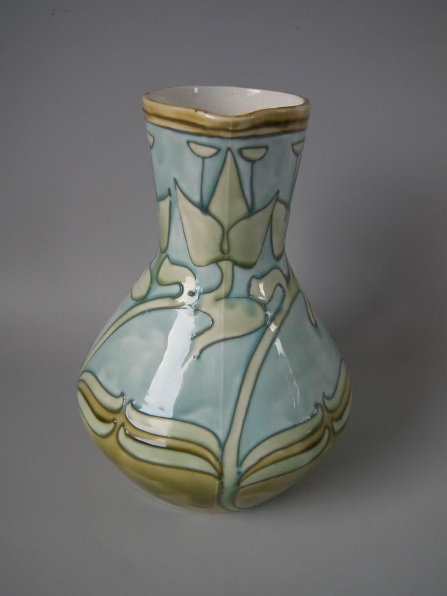 Minton secessionist no.6 pitcher. Decorated with gray tube lining on ochre ground. Cream interior and underside. Printed maker's marks, including 'MINTONS LTD No.6' and impressed 'MINTONS', '28' and date cipher for 1907.
 
