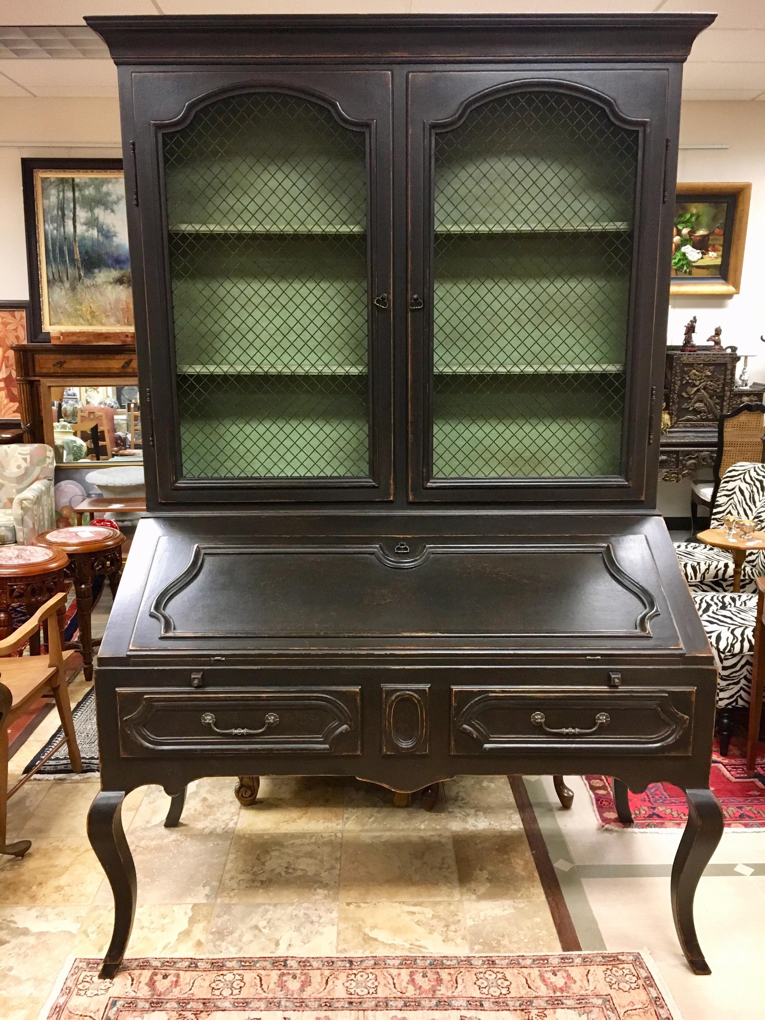 Stunning and sought after Minton Spidell Louis XV secretary in a black distressed exterior and a sea foam green interior. Chicken wire doors open to shelves. Comes in two pieces, top and bottom.
Features several drawers inside and outside. An