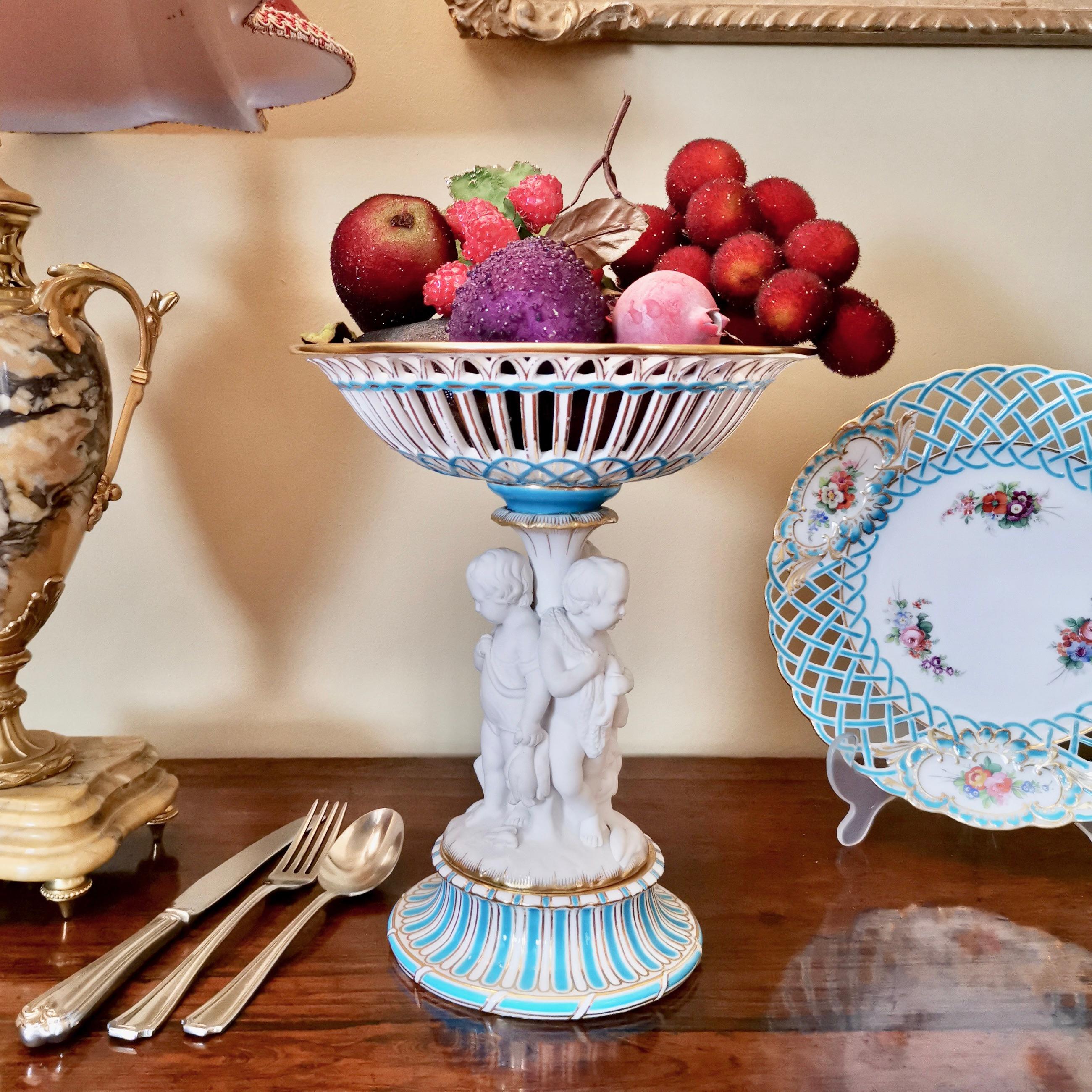 This is a beautiful tazza or comport made by Minton in circa 1880, which was the Victorian era. The stem of the tazza holds three white Parian porcelain hunting cherubs and their dog. This tazza would make a fabulous display on your Thanksgiving or