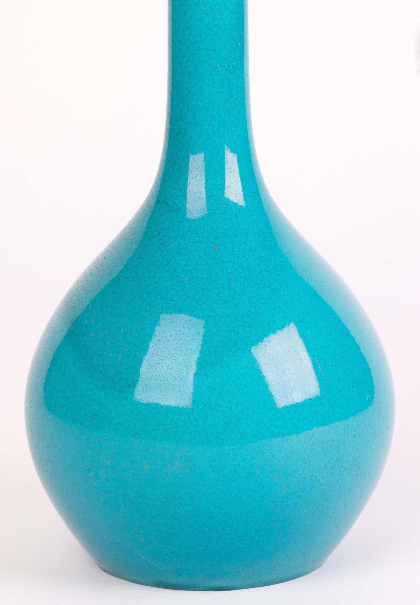 A stylish and elegant English art pottery bottle shaped vase decorated in turquoise majolica glazes made by Minton and dated 1852. The vase stands on a narrow round unglazed foot with a recessed base and with a rounded lower body and tall slender