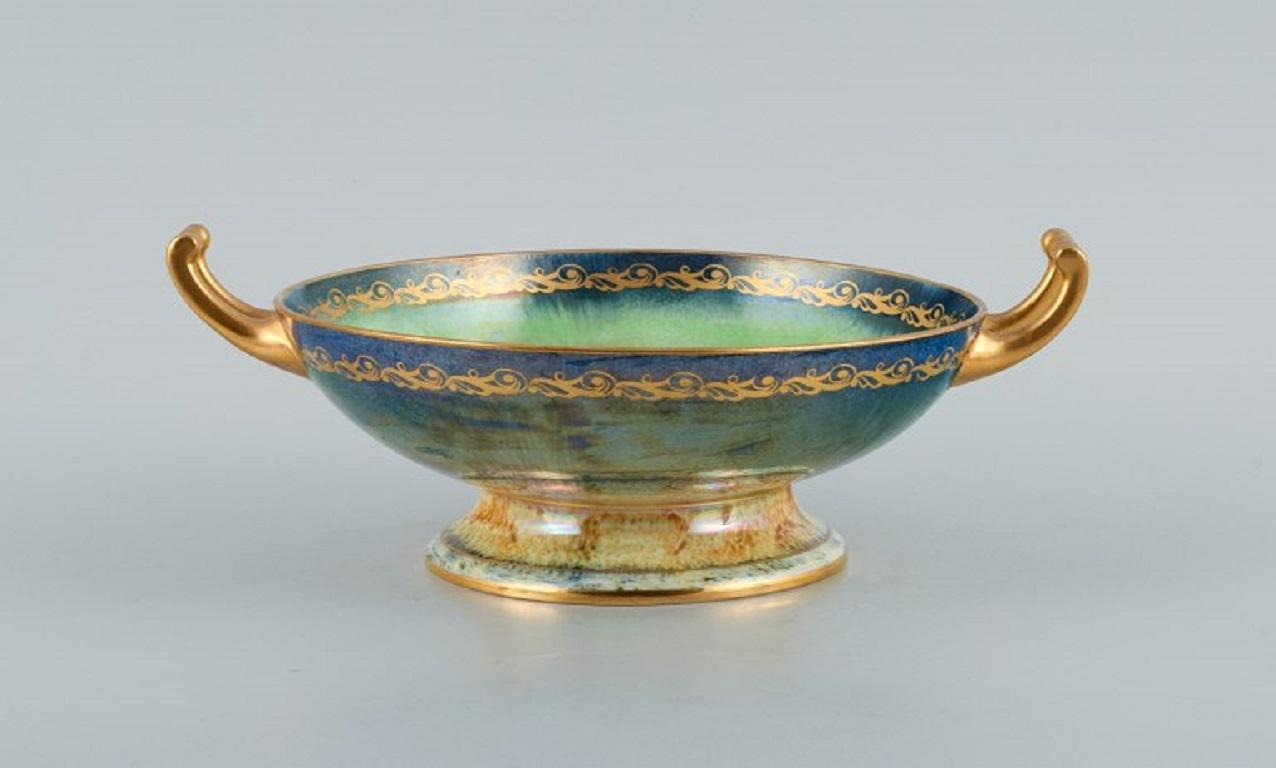 Mintons, England, porcelain bowl with handle. Hand-painted with fruits and decorated with gold leaf.
1920s/30s.
Marked.
In perfect condition.
Dimensions: D 21.0 (27 with handle) x H 8.0 cm.