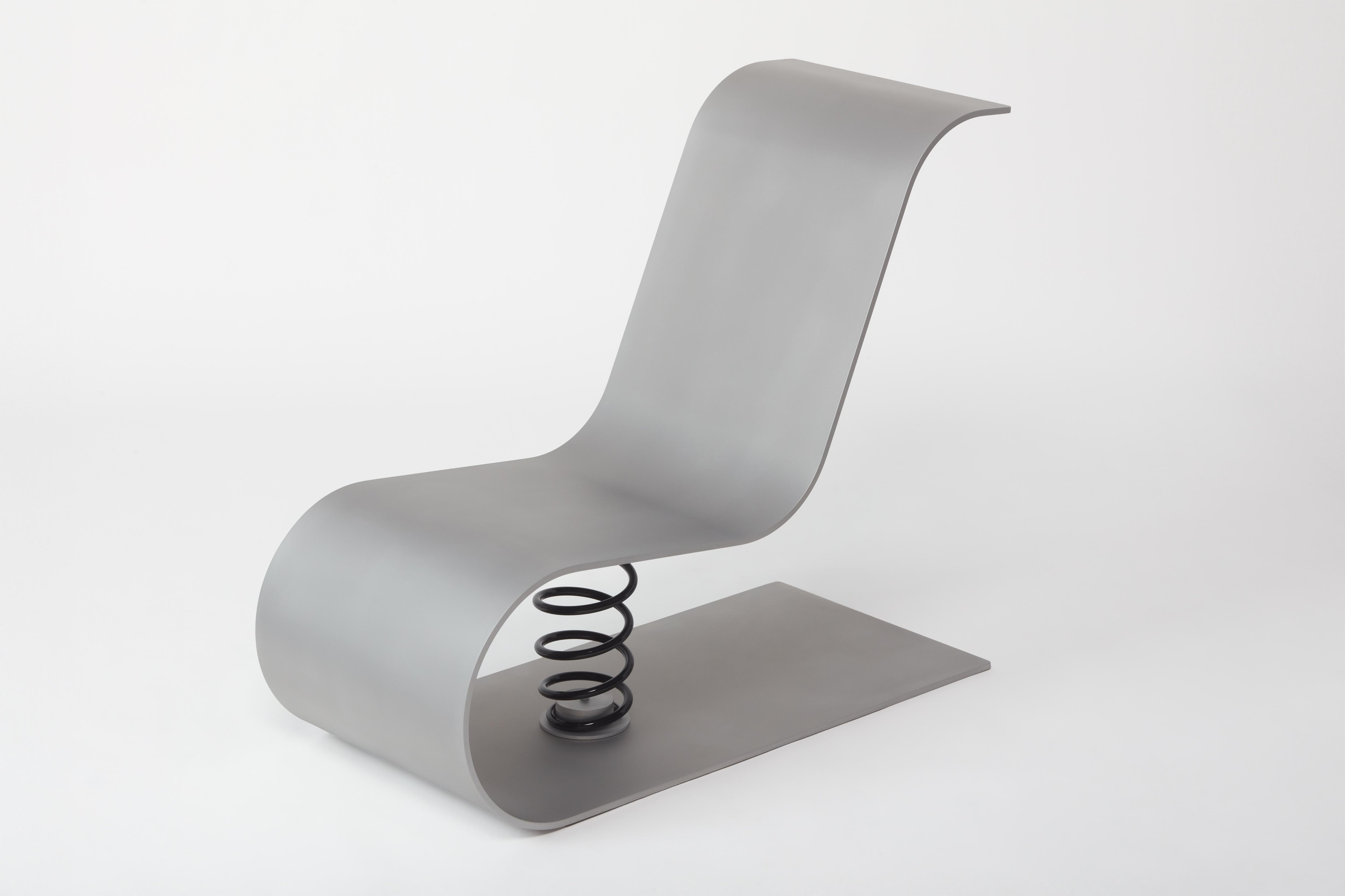 Sedia a dondolo realizzata con un'unica lastra di alluminio piegata da 10 mm con finitura sabbiata e cerata. Realizzato dallo studio di design Kutarq Studio di Valencia.

MINUS è una poltrona scultorea e monomaterica di Kutarq Studio, realizzata da