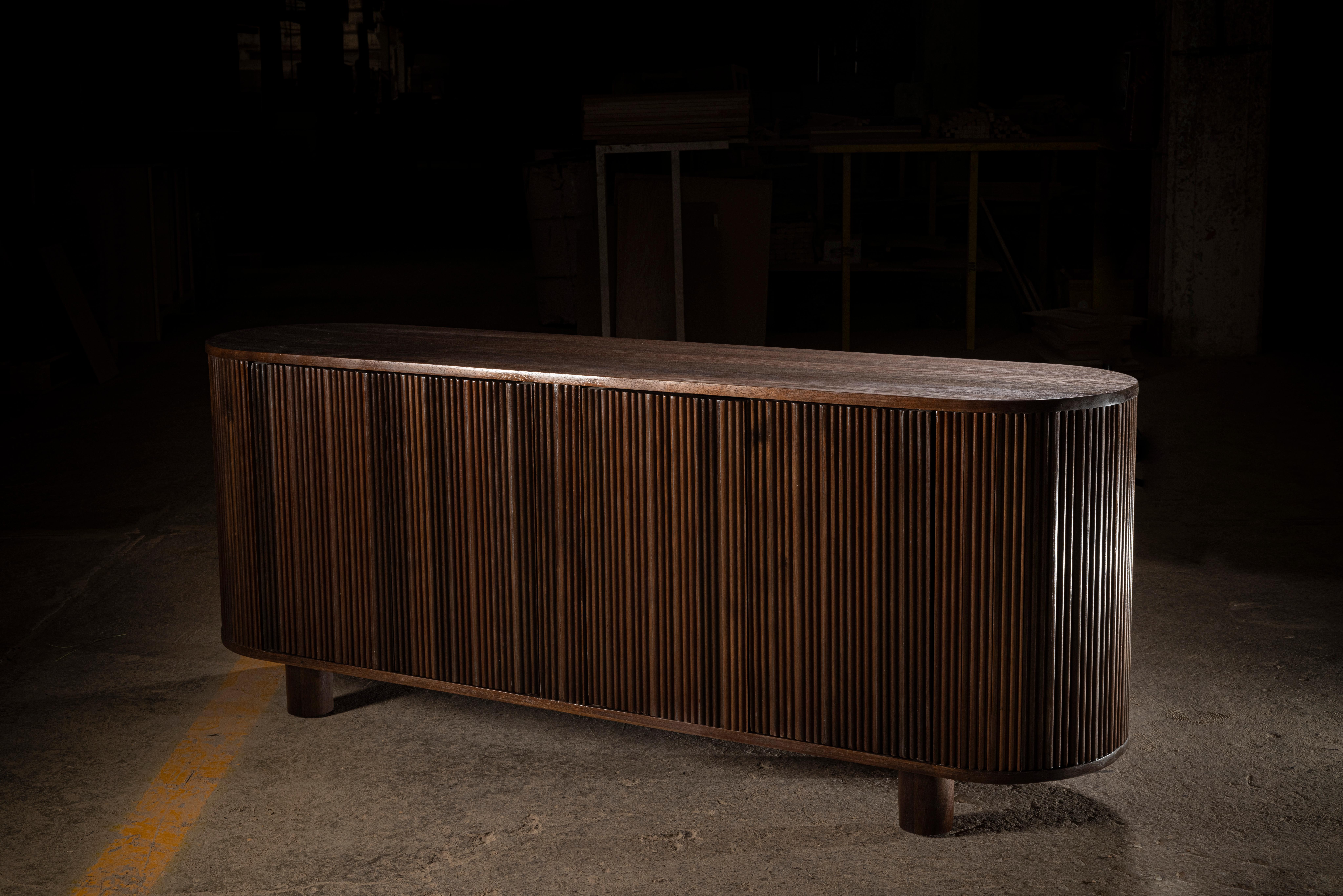 Oval shaped, hand-crafted solid Peruvian walnut sideboard.
It has 4 hidden doors and 2 shelves on the inside for storage.
