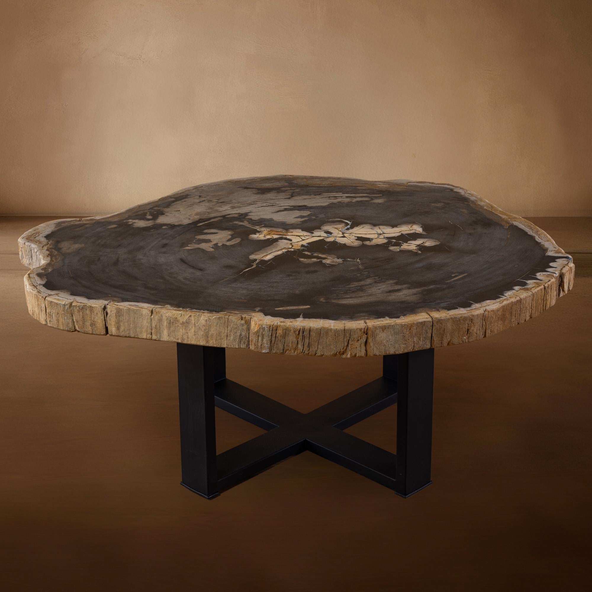 This exquisite center table is a true masterpiece, originating from Indonesia, with a slab of wood dating back 20 million years to the Miocene era. The slab features its original natural edge, adding a unique and organic touch to its