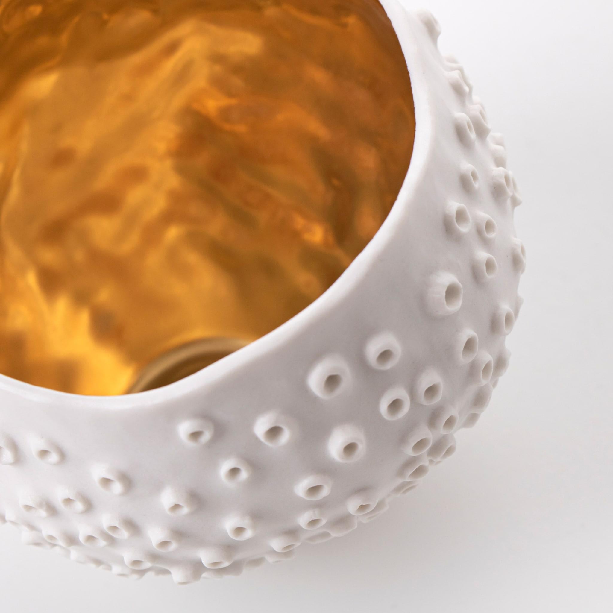 Inspired by the spectacular shapes and textures found in marine life, this delicate cup features a textured surface with tiny raised rings that evoke the exotic reef corals. Entirely handcrafted of white porcelain with a glossy finish, this