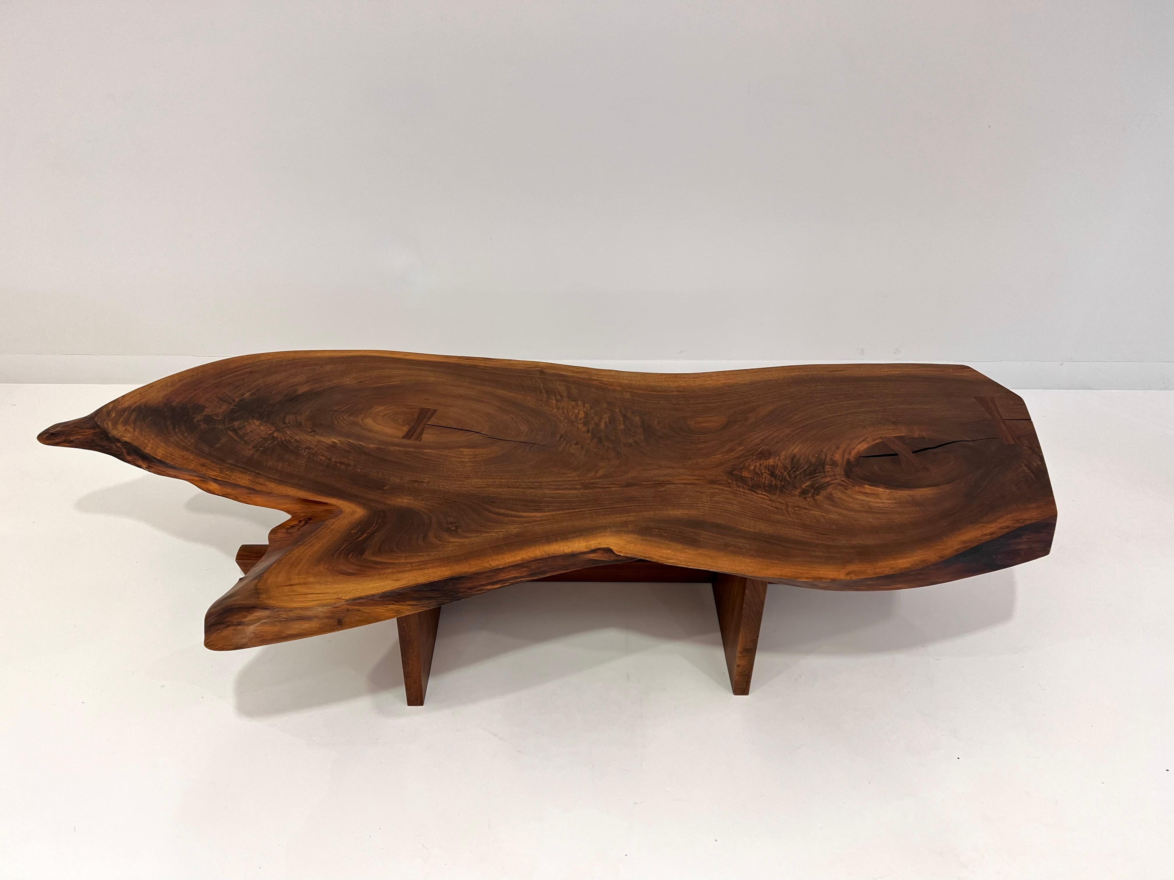 Stunning Live Edge Coffee Table by Mira Nakashima, in black walnut with dramatic variation in the grain, knot details and three rosewood butterflies. Raised on two slabs and stretcher. Signed and dated on the underside.