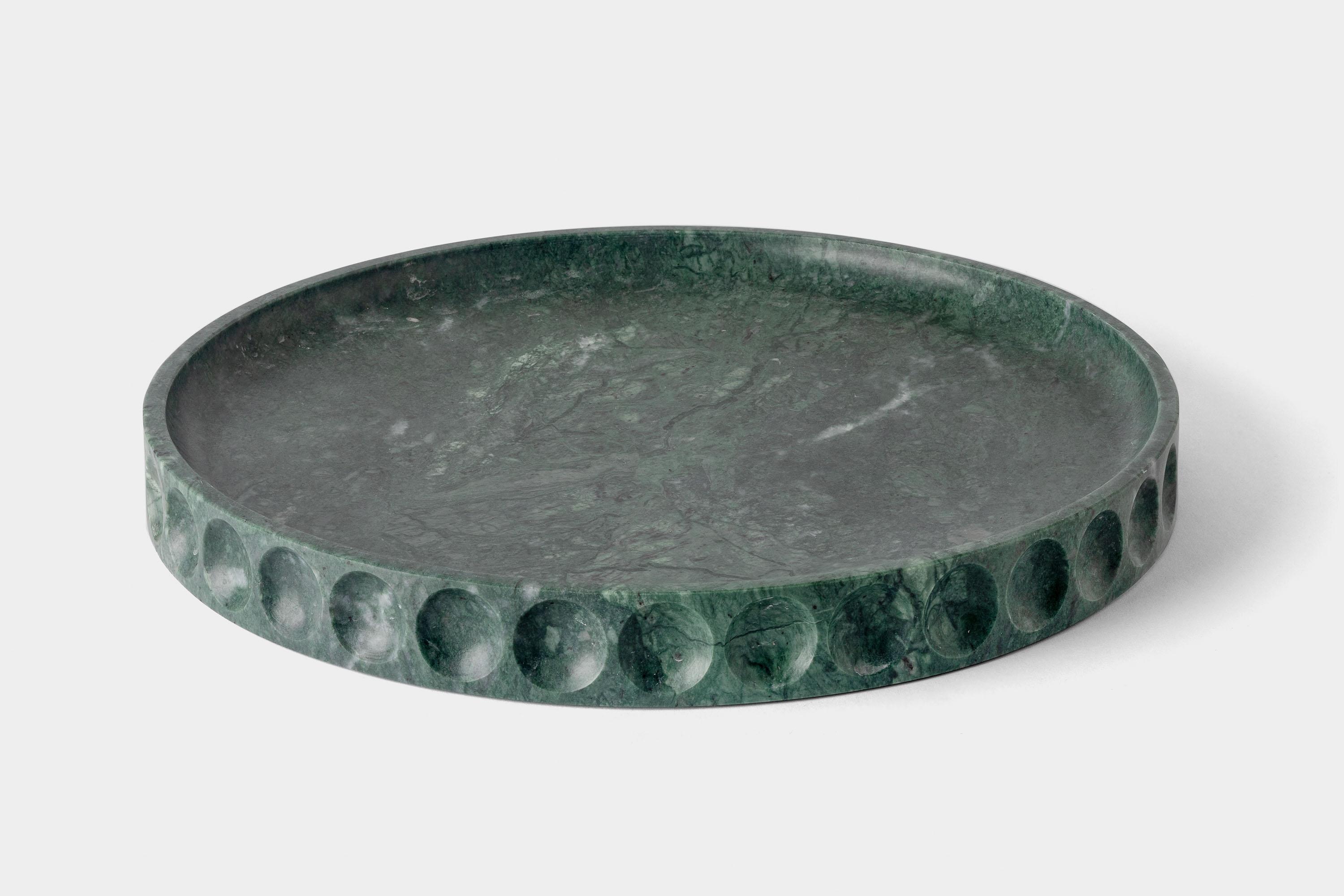 Mirage Contenitore basso di Studio A
Dimensioni: D 30 x H 3,2 cm
Materiali: marmo verde del Guatemala.
Disponibile in altre pietre.

La collezione Mirage nasce dalla materialità monolitica della pietra. Forma e funzione coincidono, creando un