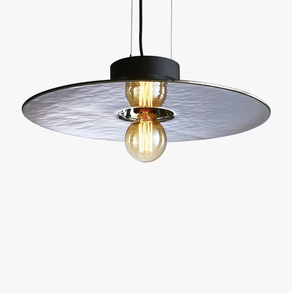 Mirage pendant light, silver & large by Radar.
Design: Bastien Taillard.
Materials: Thermoformed silver glass, metal.
Dimensions: H 10 x D 70 cm.

Also available: In gold, bronza or iris and size Small (Diameter: 50). Base available in black