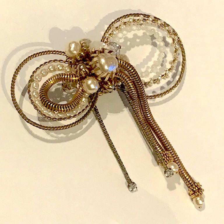 A beautiful, lovely and a very fine large bow brooch by Miriam Haskell. It has a soft antique gold tone patina know as Russian gold by the company. Faux small and large baroque pearls, medium size faux grey pearls, crystal and mother of pearl beads.