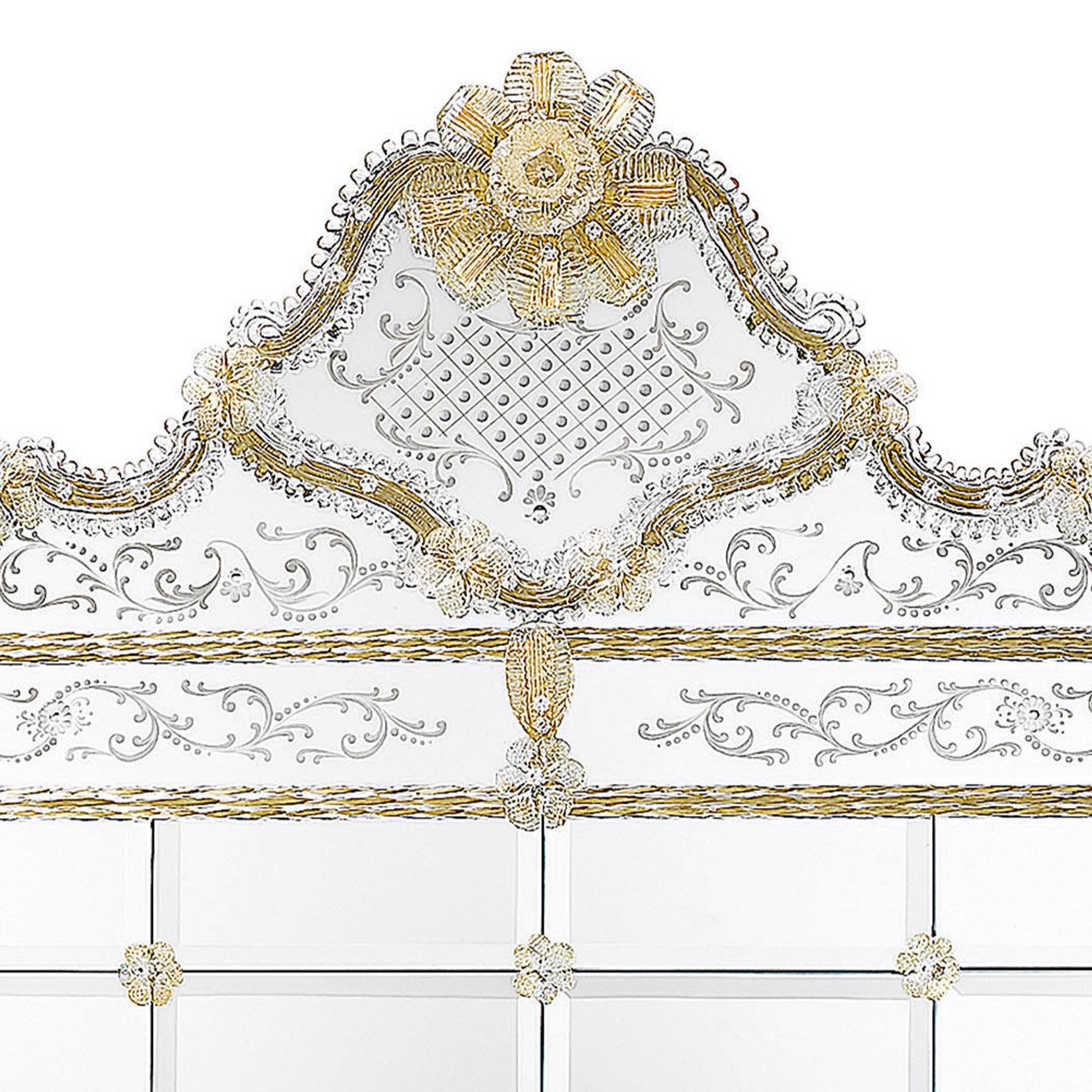 Hand-engraved in the traditional Venetian style, this horizontal mirror has an impressive presence, both for its dimensions and artistic quality. Structure made of wood with walnut colour finish. Central bevelled glass tiles with clear mirrored