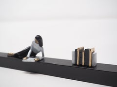 Beyond the page – Wandskulptur aus Bronze und Eisen mit liegender Frau und Büchern