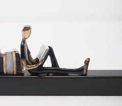 "Capitoli allegri" scultura figurativa contemporanea in bronzo da parete che legge libri