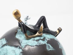 Laid back- figurative bronze sculpture of a man with a dog on a globe