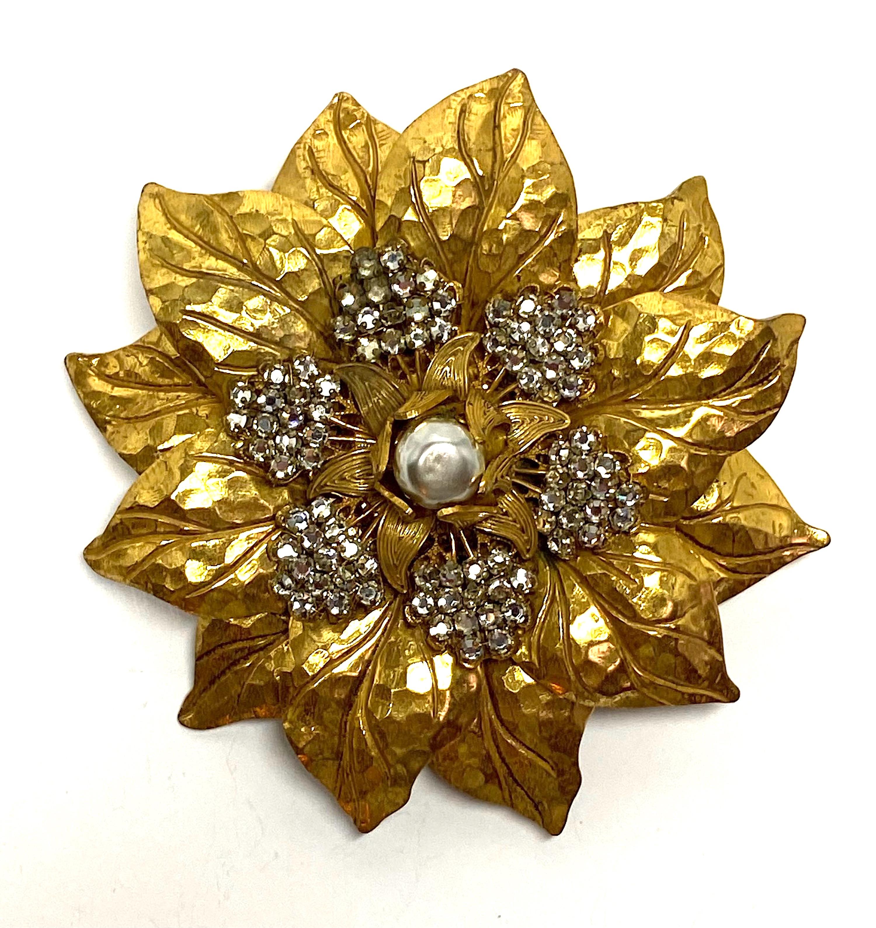 A beautiful and large there dimensional 1950s Miriam Haskell flower brooch. It is 3 inches in diameter. The brooch is  constructed in five stacked layers of floral disks. They are wired together as are the top flat back crystals. The top has a faux
