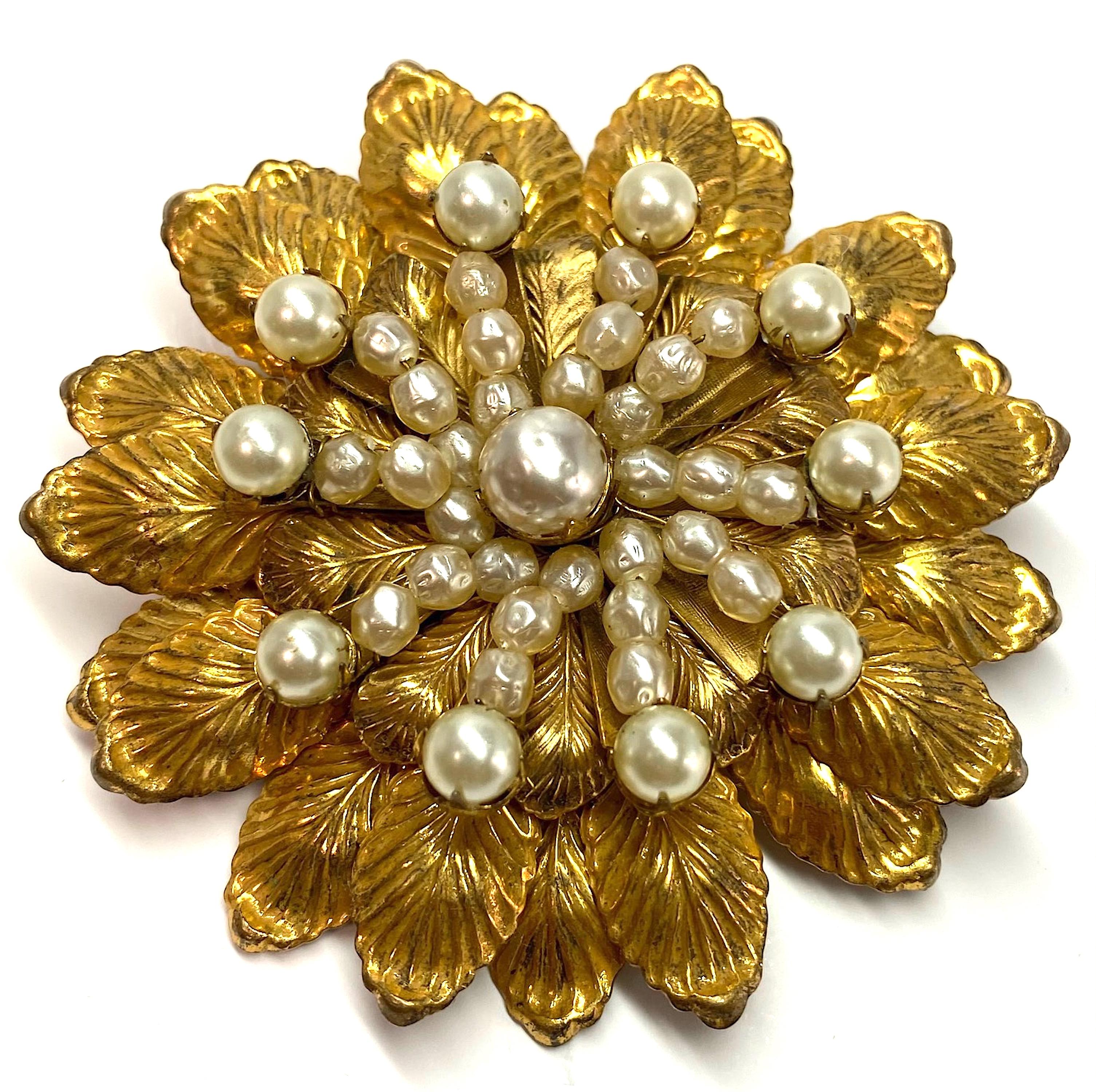 A beautiful and large there dimensional 1950s Miriam Haskell flower brooch. It is 2.75 inches in diameter. The brooch is  constructed in three stacked layers of floral disks. They are wired together as are the top Pearl accents. The back has a