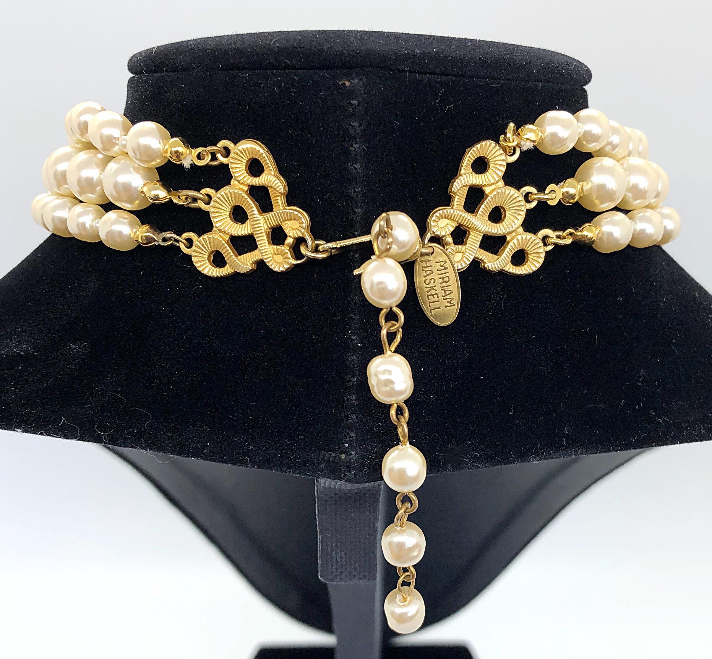 Spectacular vintage 50s signed MIRIAM HASKELL triple strand freshwater faux pearl choker necklace! Features three strands of ivory colored graduated pearls. The center focal pendant is a signature large flower embellished with hand-sewn seed pearls