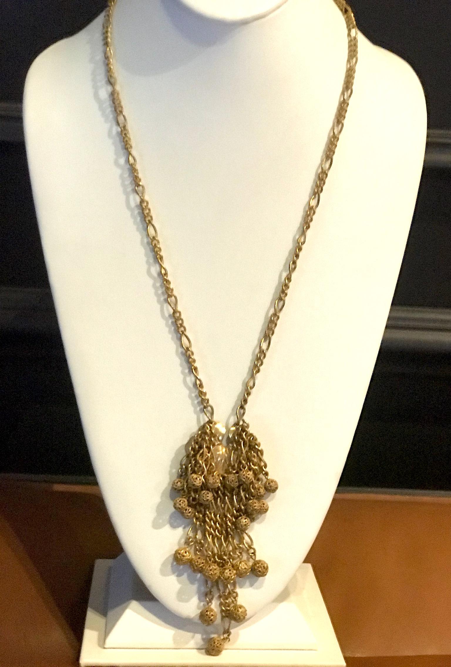 A vintage 1960s Miriam Haskell necklace in her famous Russian Gold finish. The necklace pendant is a lily pad hidden behind the chain fringe. Each of the chains from the lily pad is finished on the end with a filigree ball. The chain of the necklace